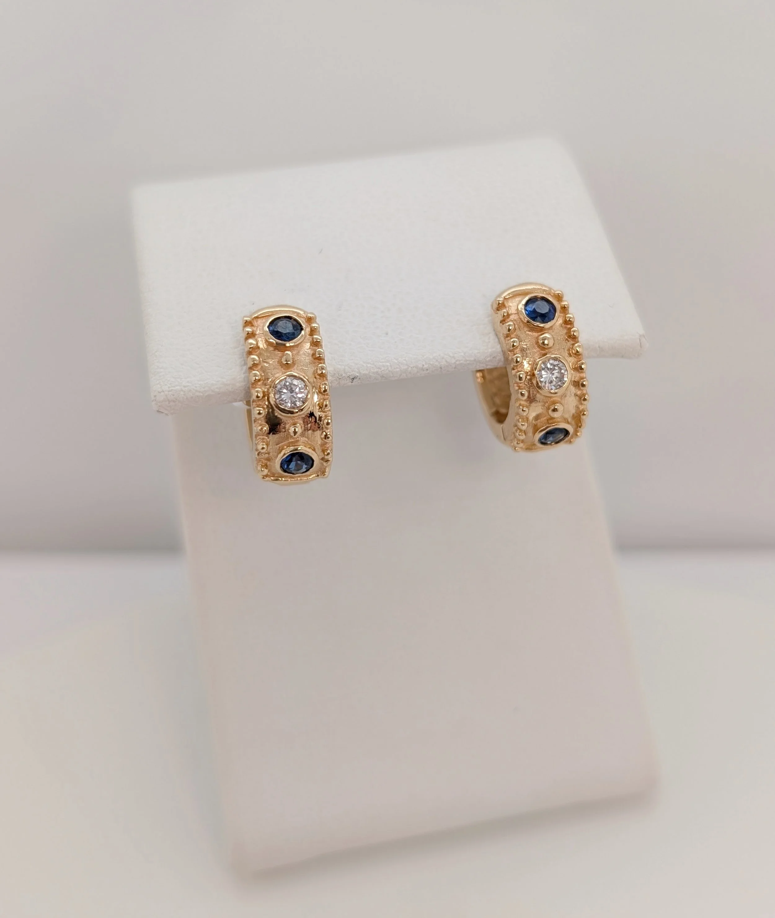 14k yellow gold sapphire and diamond huggies with milgrain edges. (210-3722)