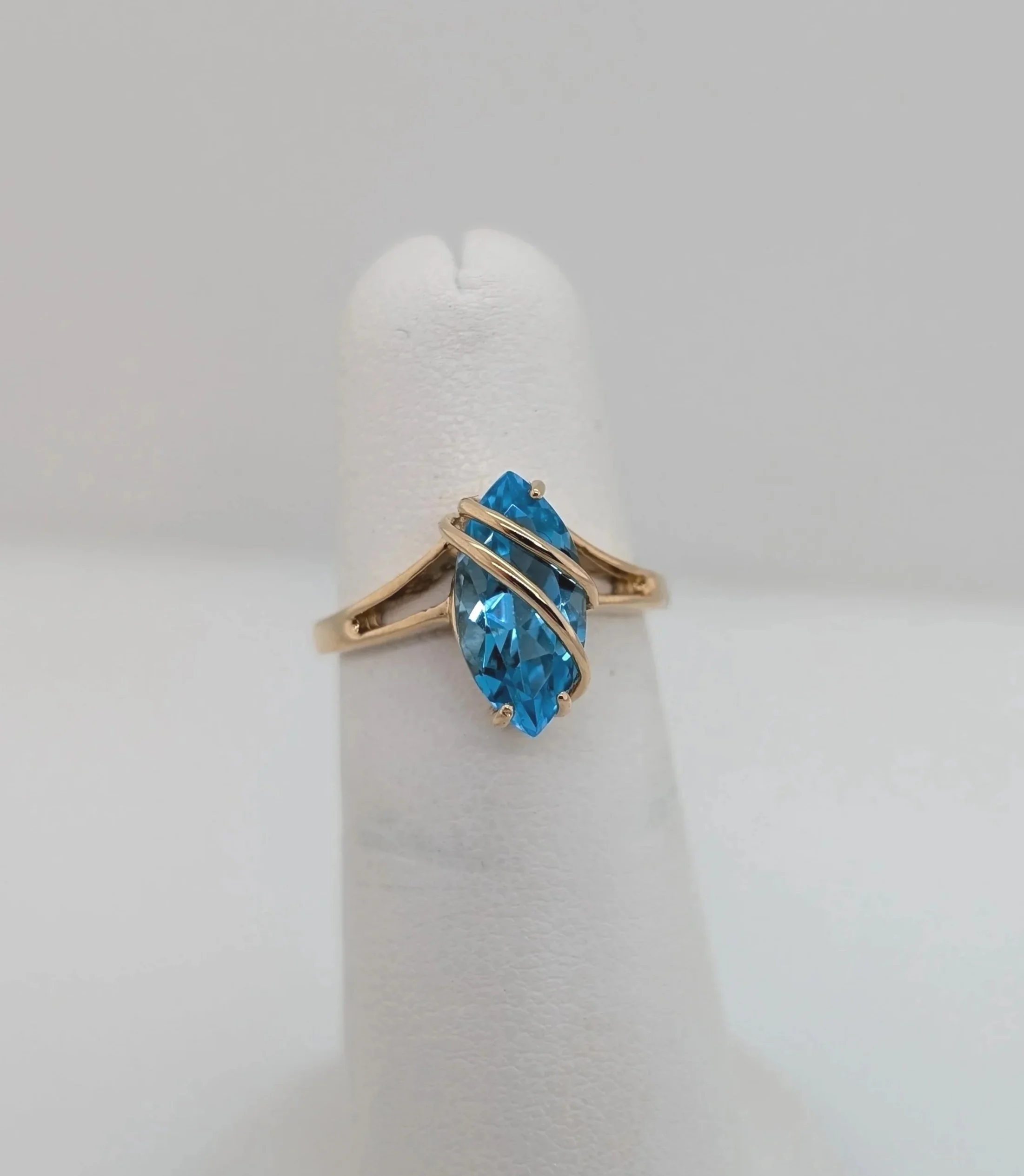 14k yellow gold crossover blue topaz ring with split shank. Size 4.4. (200-2117)