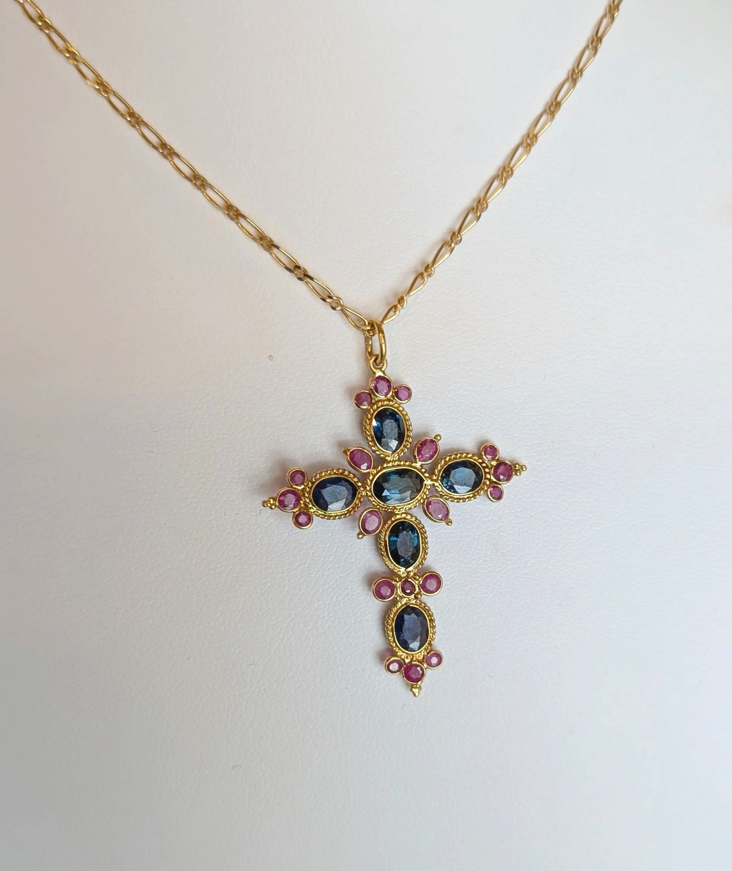 18k yellow gold sapphire and ruby cross on an 18k yellow gold figaro chain. (230-1655)