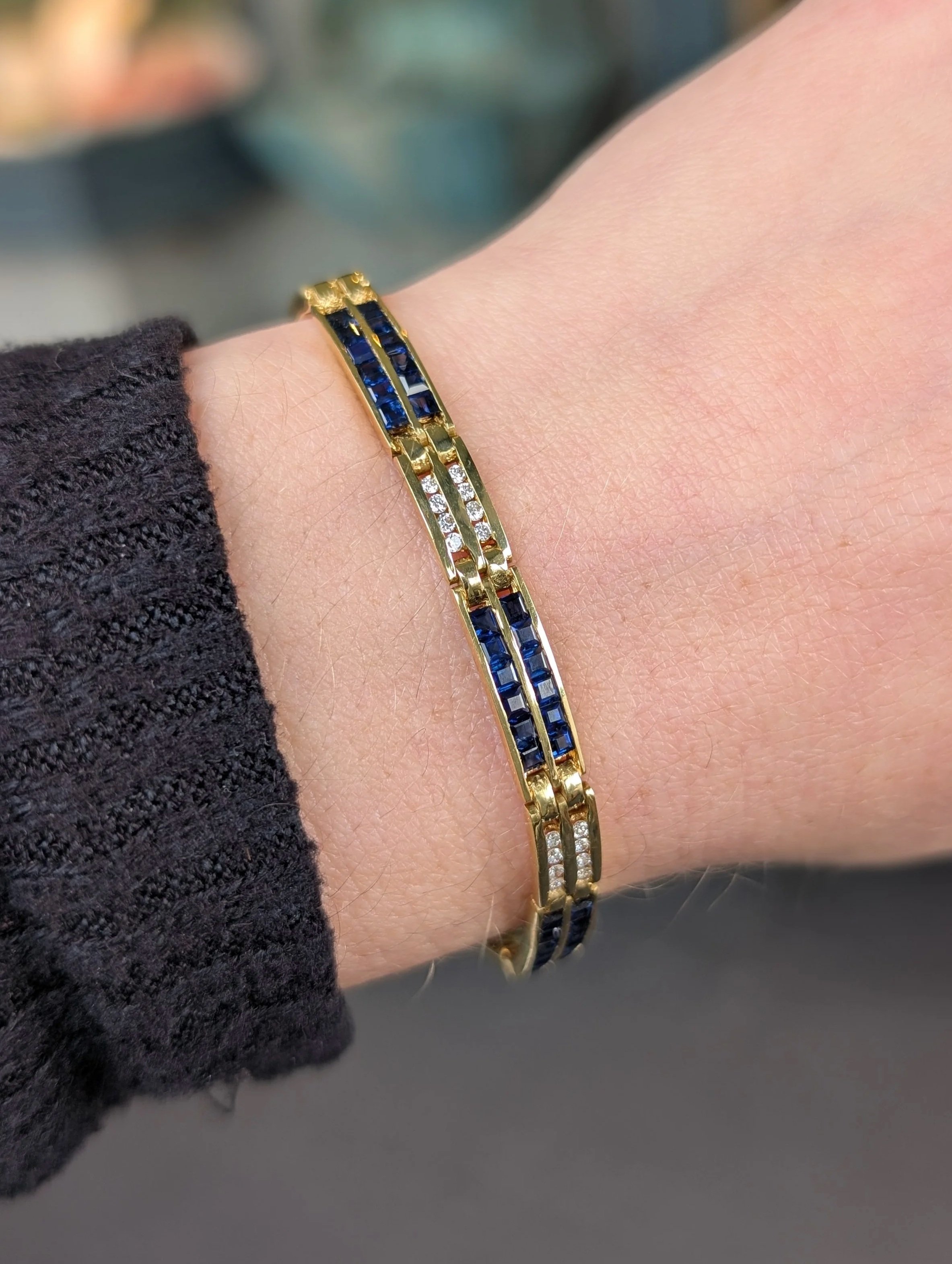 18k yellow gold sapphire and diamond bracelet channel set with 72 princess cut sapphires and 48 round diamonds. 6.75 inches. (240-1180)