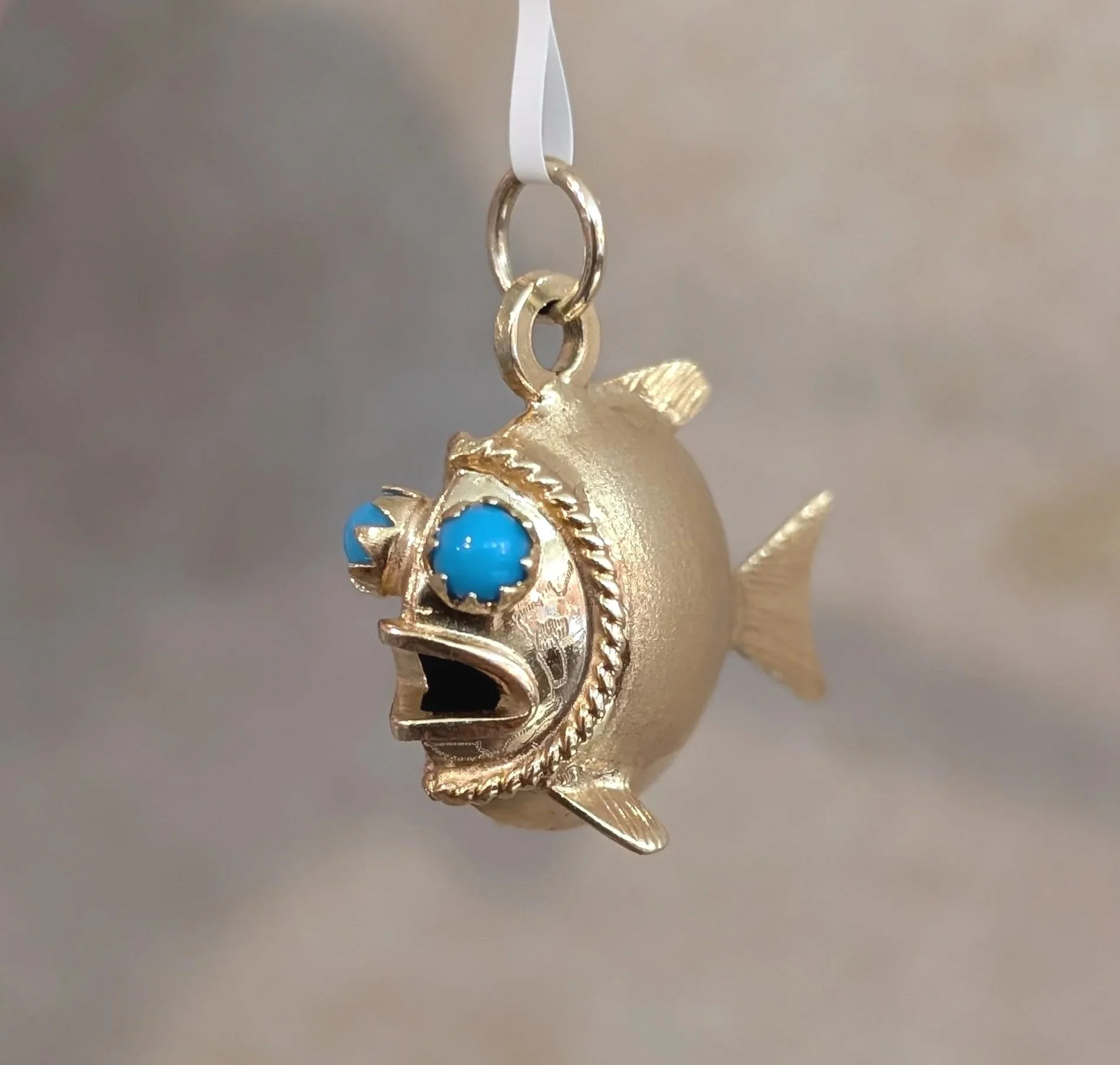 18k yellow gold 3D fish charm with turquoise eyes and textured detailing. (435-3697)