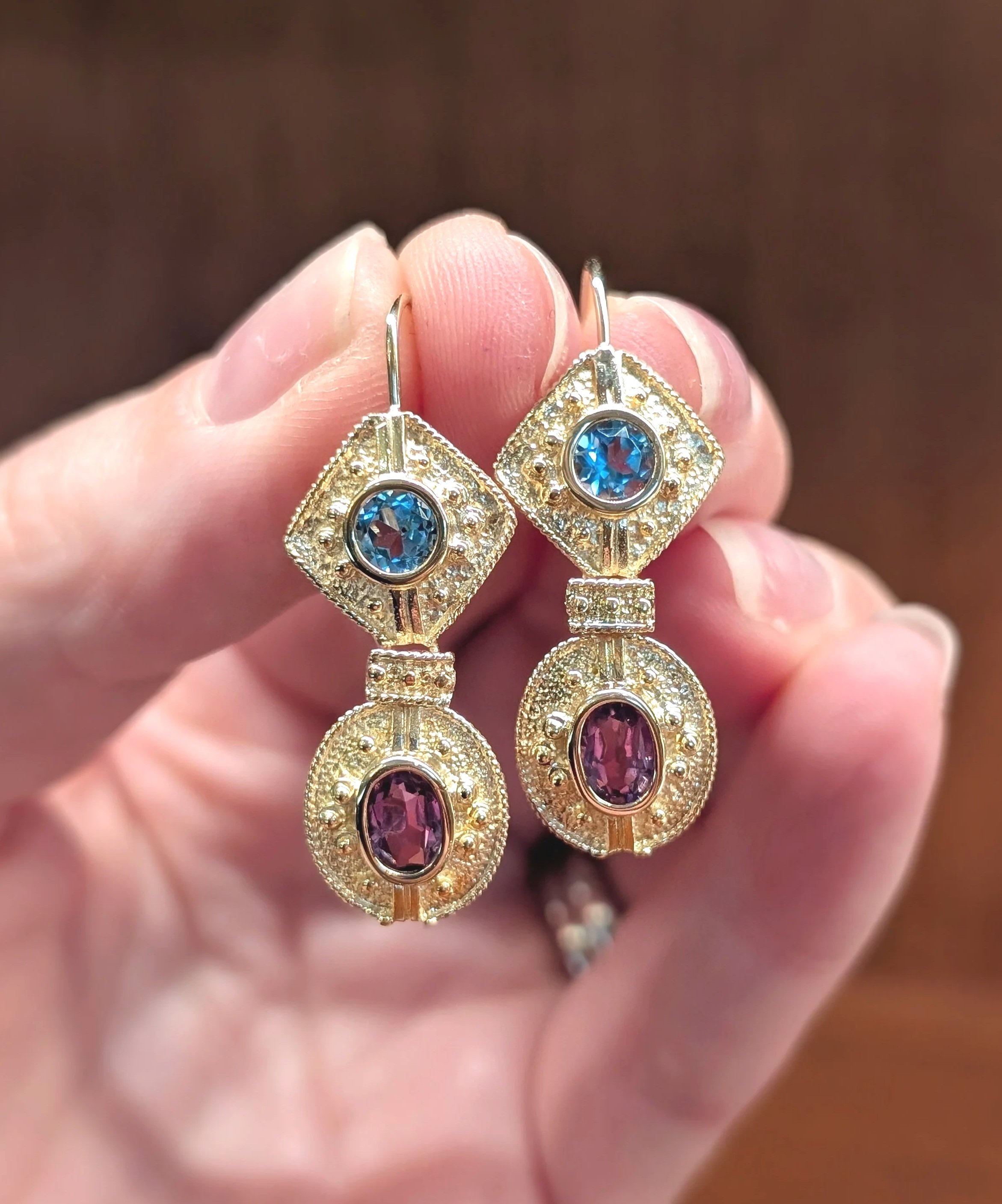 14k yellow gold textured blue topaz and amethyst dangle earrings with lever back closures.