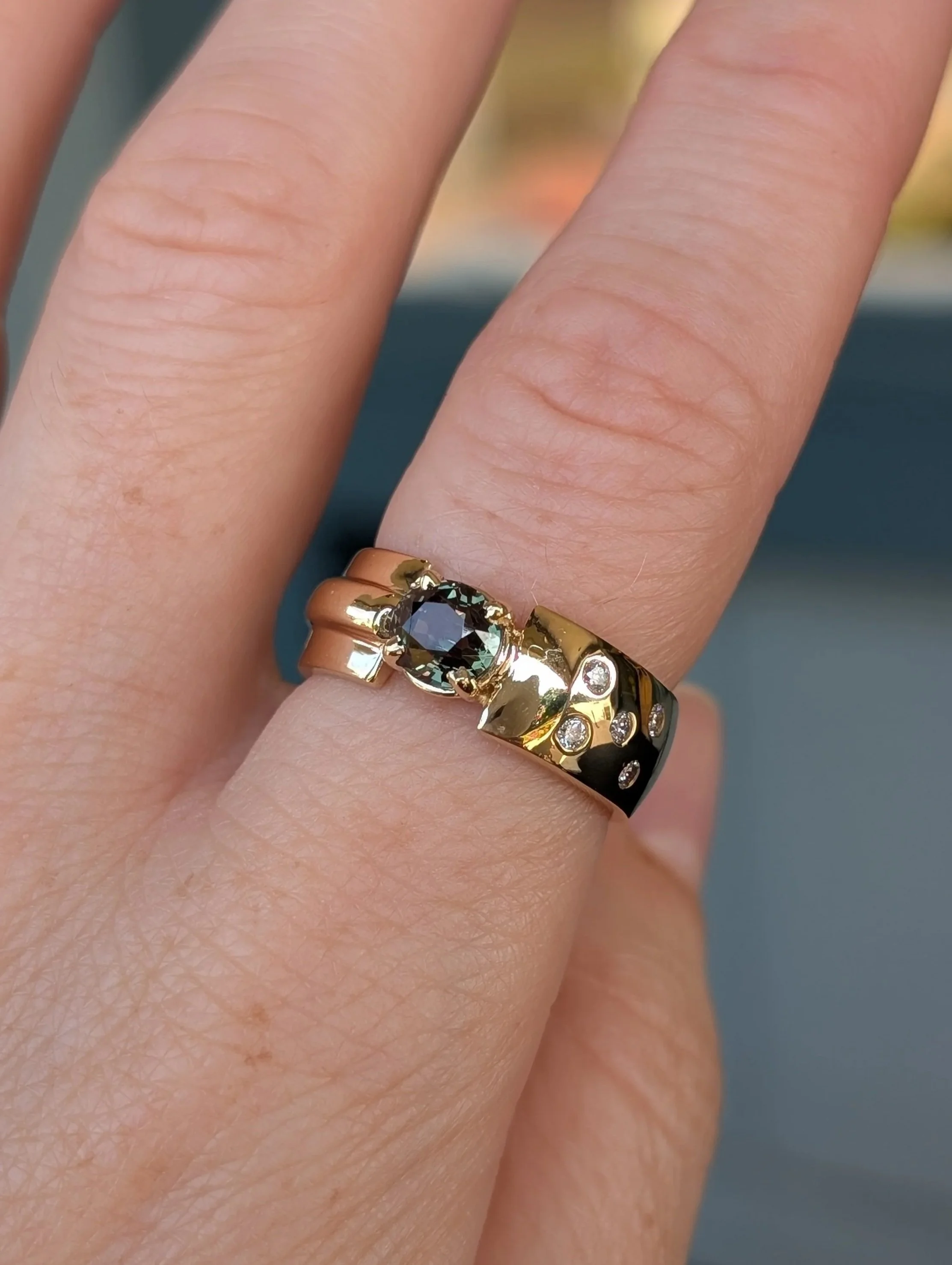 14k yellow gold wide ring set with an alexandrite and flush set with diamonds in the band. Size 7.25. (200-2242)
