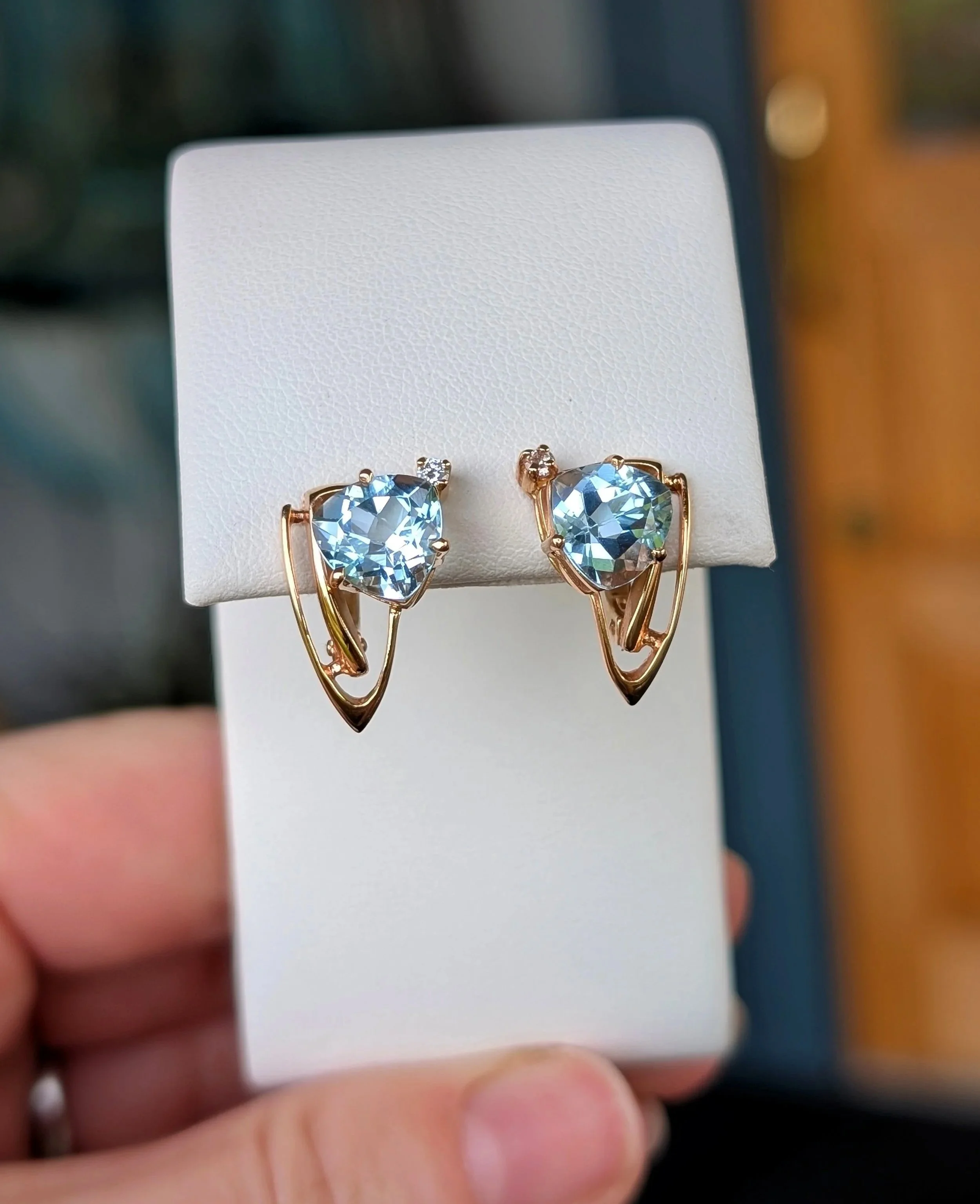 14k yellow gold trillion cut blue topaz and diamond earrings with snap post closures. (210-3649)