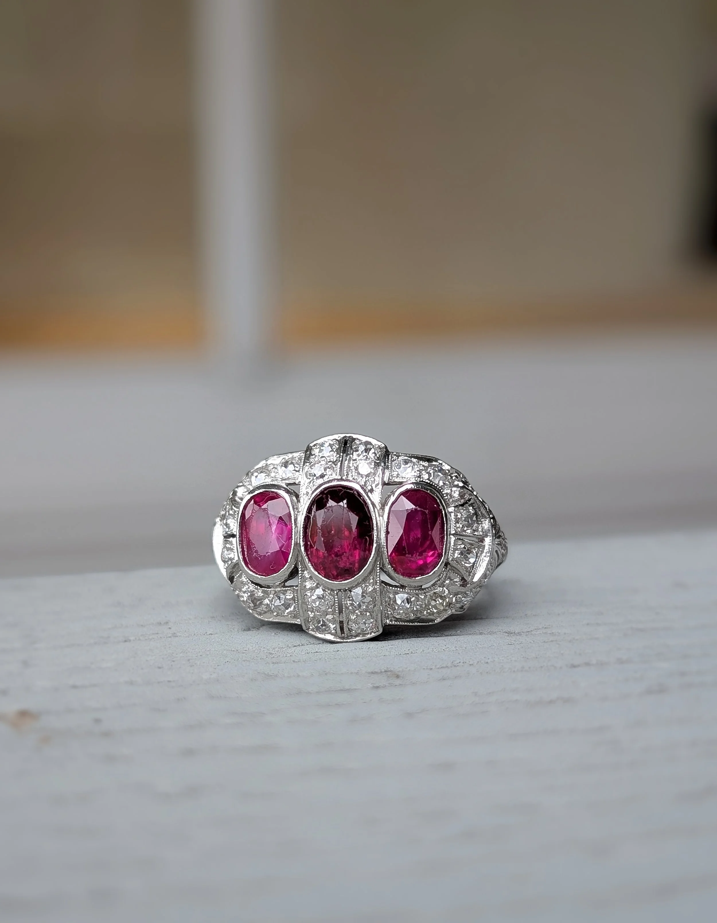 Platinum filigree ruby and diamond ring bezel set with 3 oval rubies and prong set with 30 round diamonds. Size 8. (200-2320)