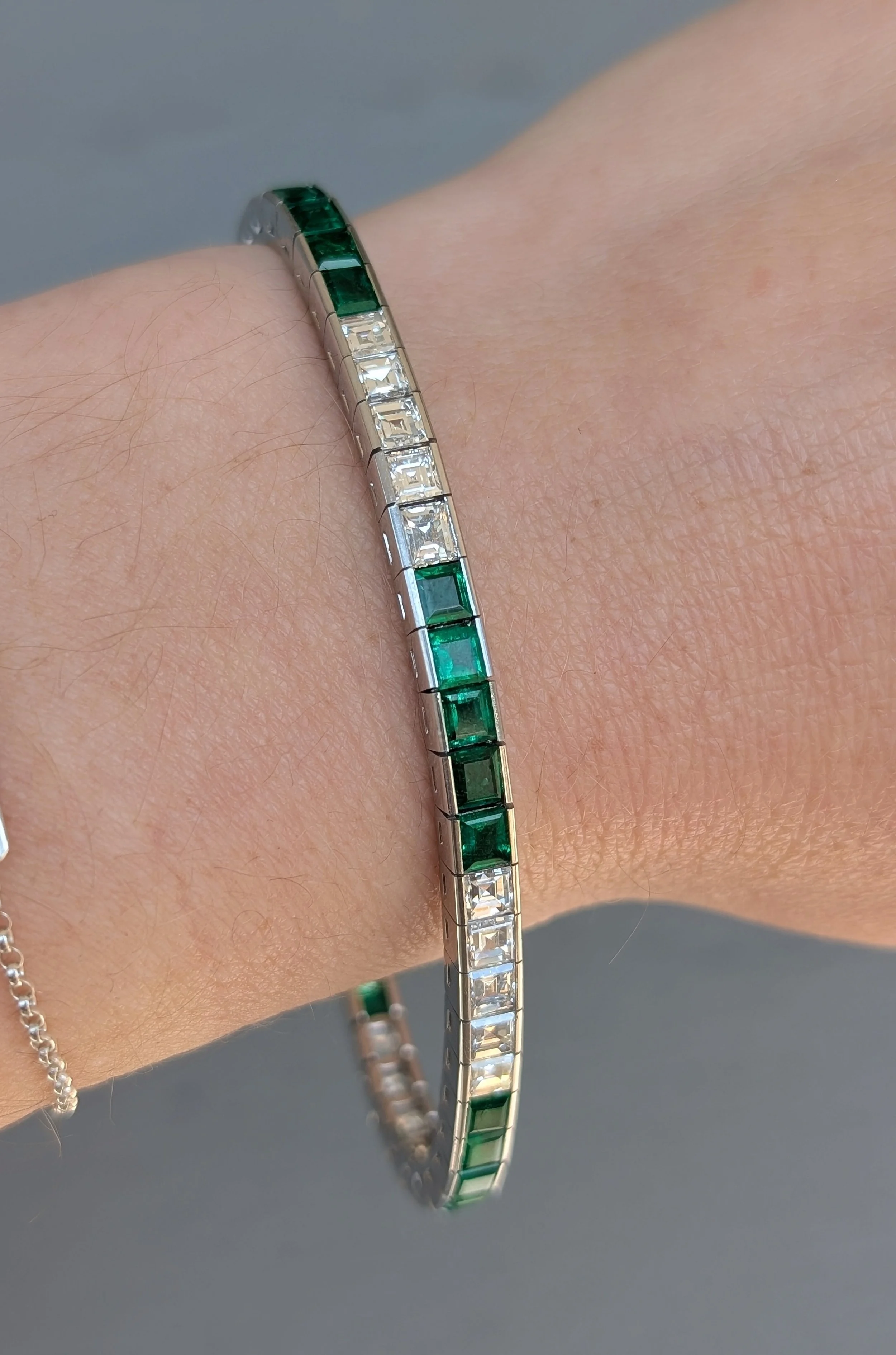 Platinum princess cut emerald and diamond line bracelet. (240-1178)