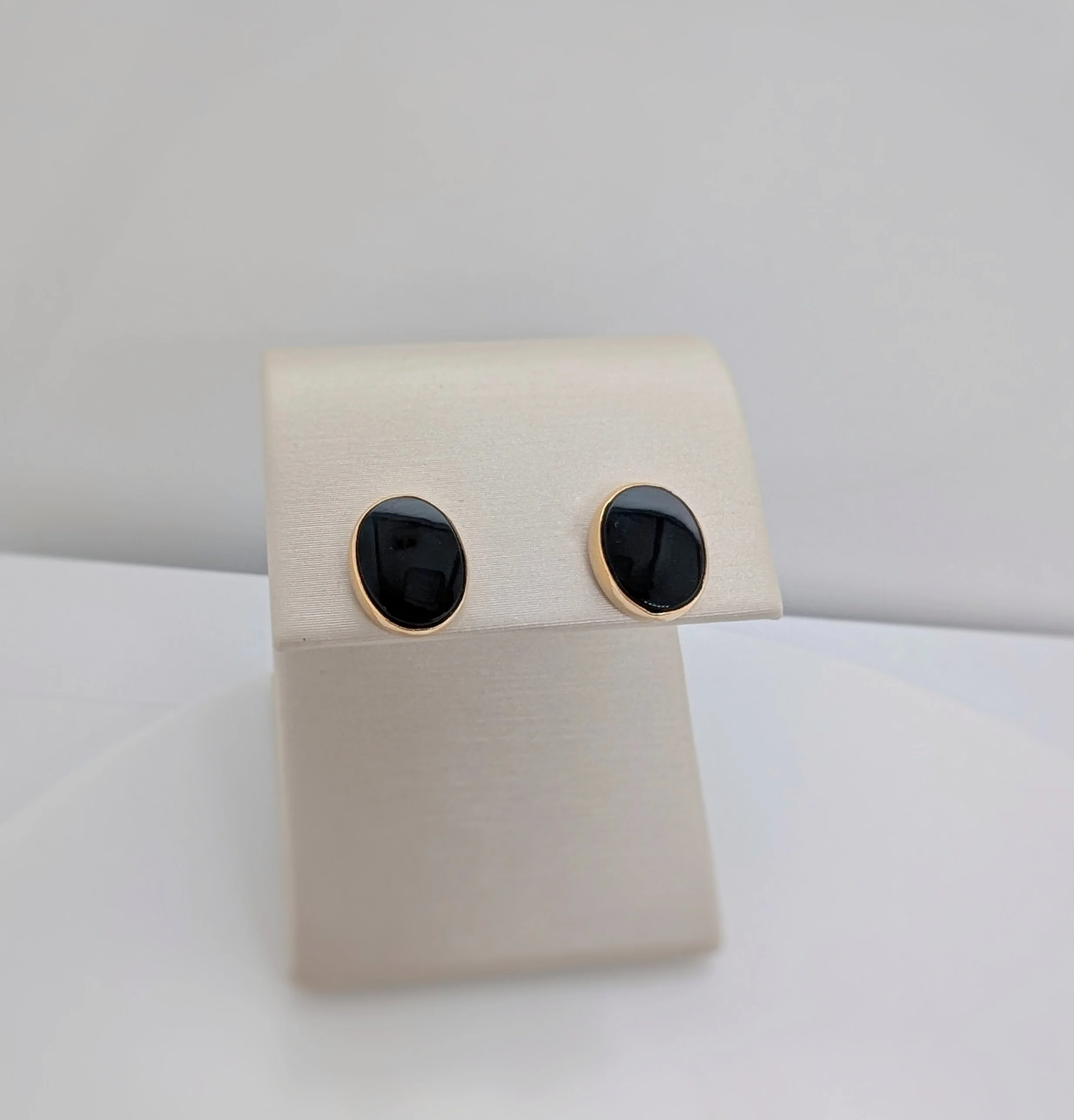 14k yellow gold oval onyx stud earrings with post and clutches. (210-3708)