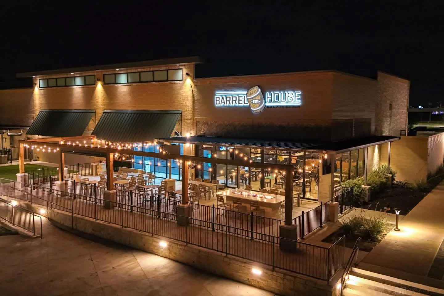Empty bar or restaurant counter with multiple beer taps, large digital screens displaying the Texas flag, and a wall sign in the shape of Texas state with 'FRISCO' written inside.