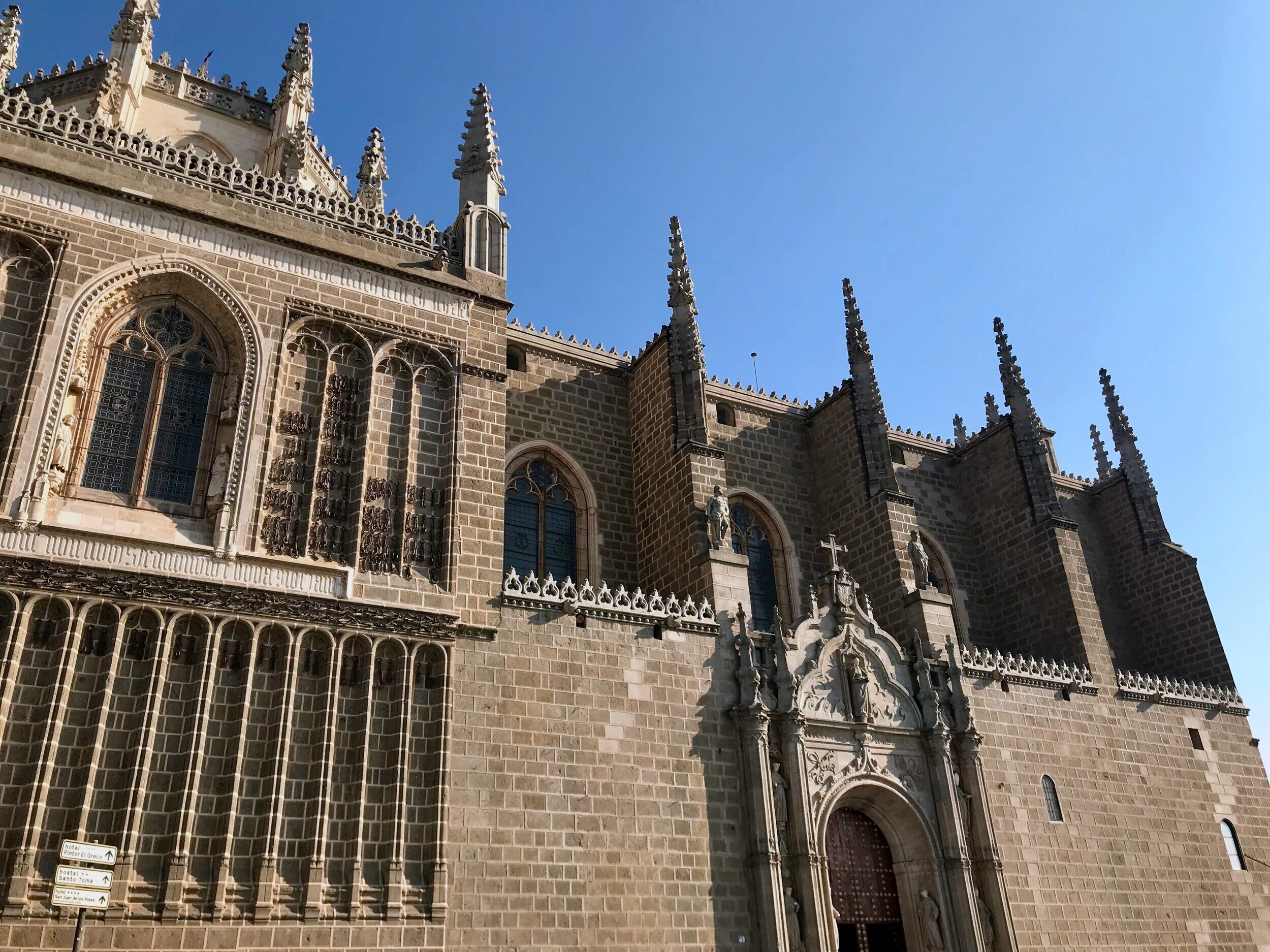 Stop 3: Monasterio de San Juan de los Reyes - From the Puente de San Martin walk up the hill on Bajada San Martin. When it dead ends, turn right on Calle de los Reyes Católicos and continue uphill.  The road will take you directly to the front doors of the Monasterio de San Juan de los Reyes. This incredible 15th-century Monastery was commissioned by Spain’s most famous Monarchs; King Ferdinand and Isabella, and is now ran  by Franciscan Monks. The architecture is incredible and the cloisters are some of the most beautiful in the world. You can tour the Monastery for only 3 euros and admire the religious artifacts, architecture, and serenity of the cloisters. There is also an option to purchase a bracelet for 10 euros that allows entry into many historical sights across the city. 