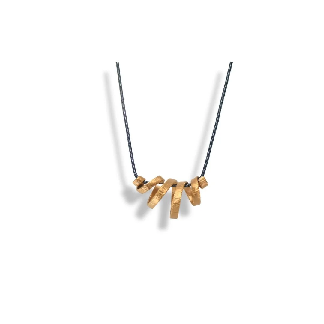 Gold Spiral Necklace that symbolizes life's journey. Its unique design and subtle texture add a touch of timeless elegance.