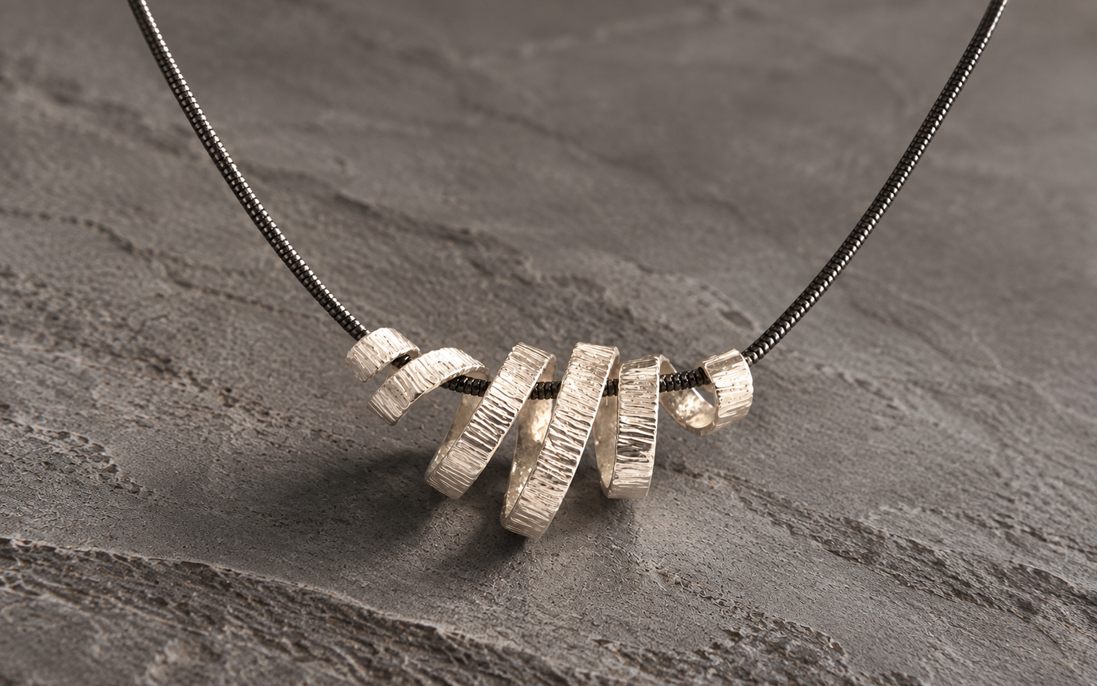 Textured Silver Spiral Pendant on Slate.png