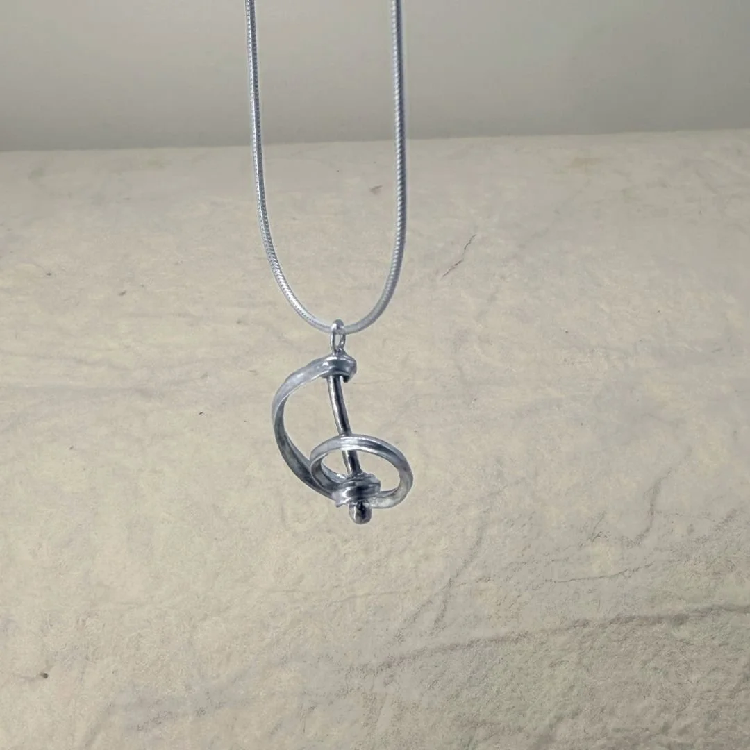 Silver music necklace with a treble-clef-inspired pendant in bright sterling silver