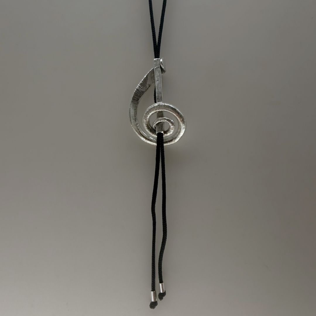 Adjustable treble clef bolo necklace showing sliding mechanism