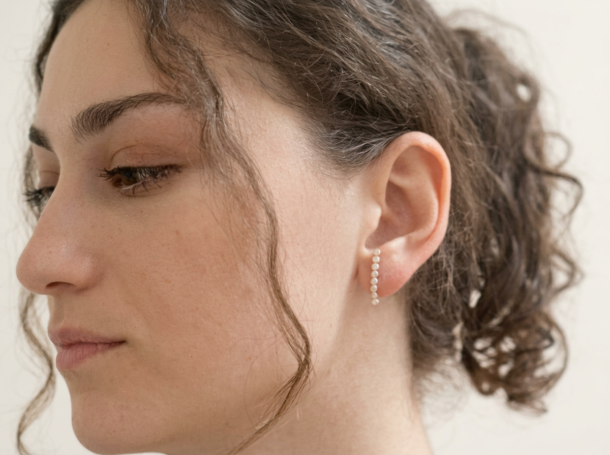 Sterling silver half hoop earrings worn on the ear