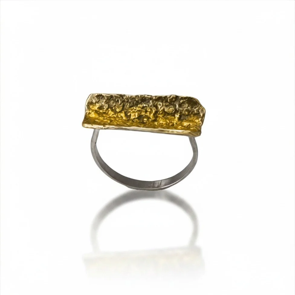 Close up photo of a sterling silver heavy textured bar ring with keum boo 24k gold details