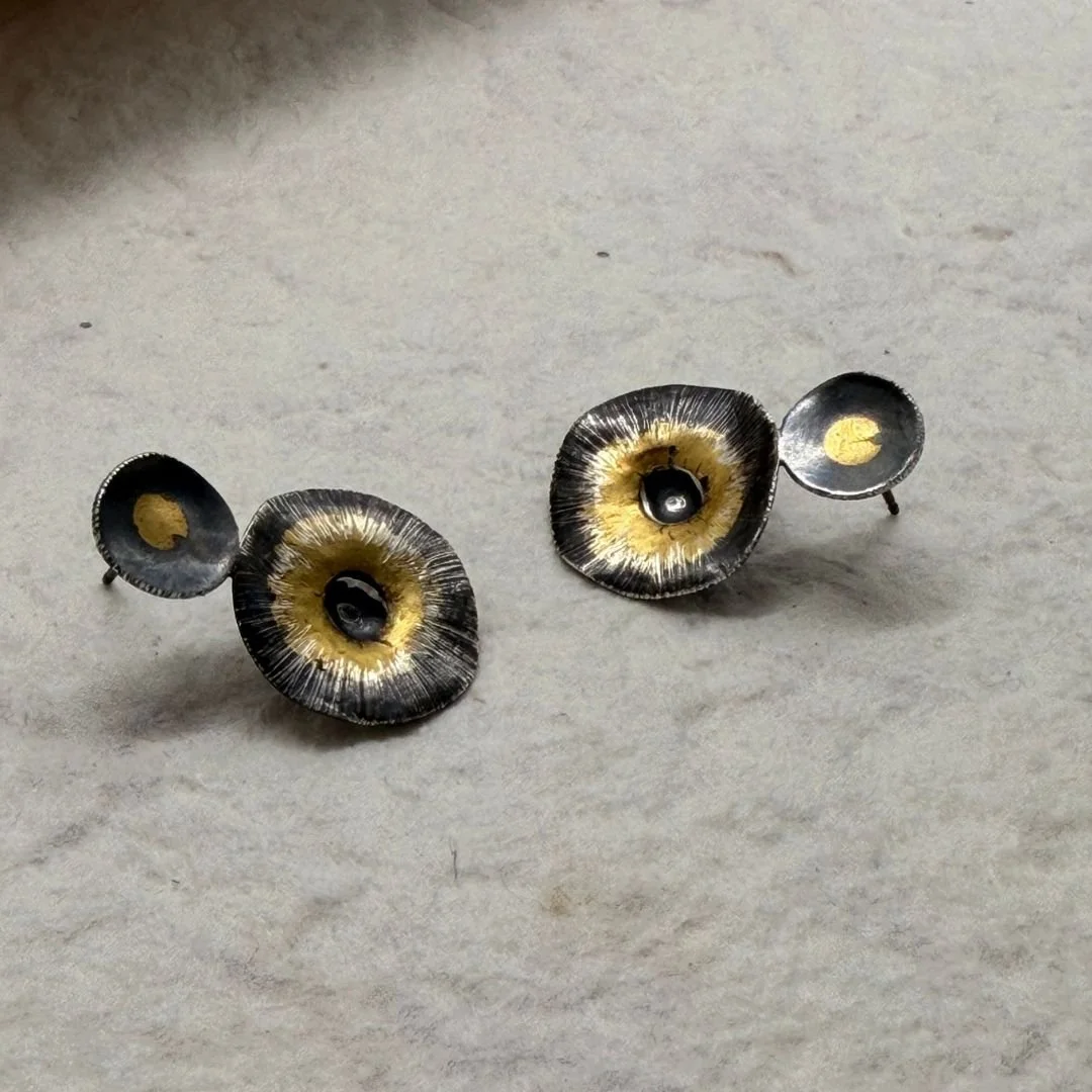 Angled view of Echo Earrings showing their shaped surfaces and ear posts
