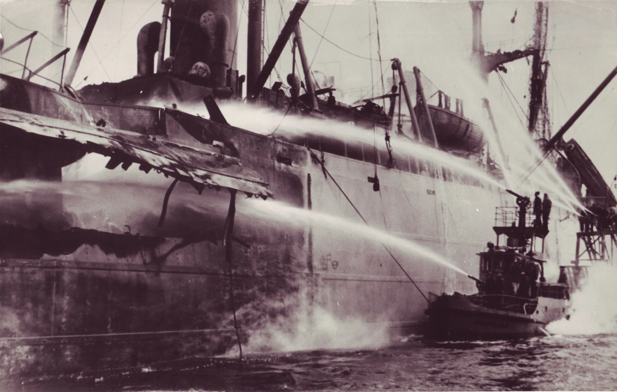 A Vancouver Harbour tugboat sprays its firehoses on the smoking S.S. Greenhill Park. -- Photo Vancouver Sun