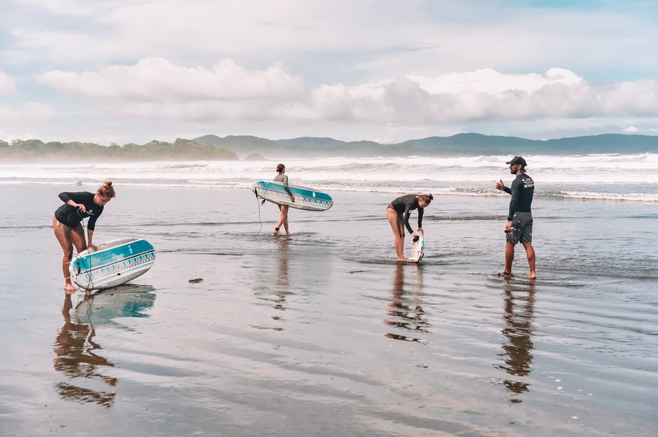 group of people with beginner surfboards on the beach
