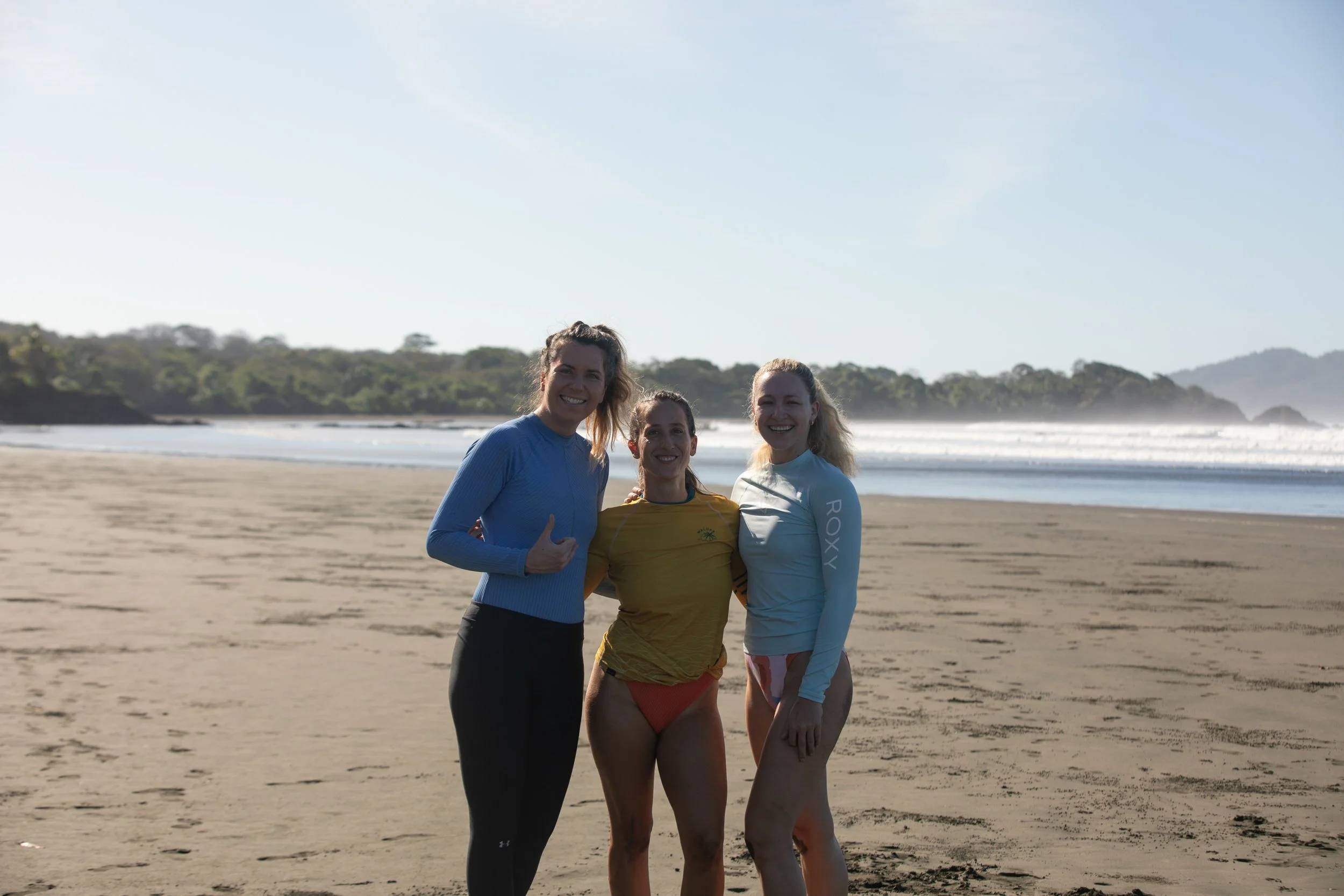 Three women getting ready for surf during a retreat in Santa Catalina