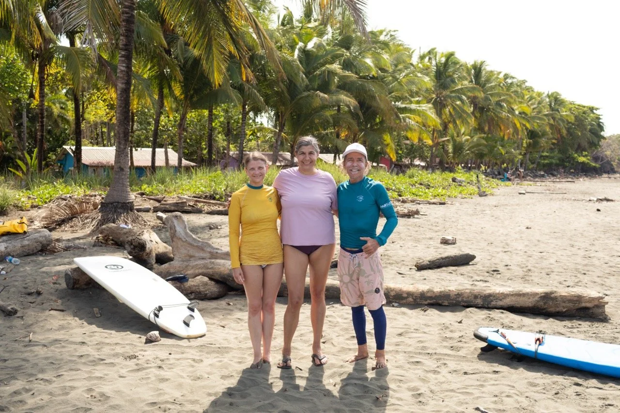 guests and instructor posing before they head out for a surf lesson