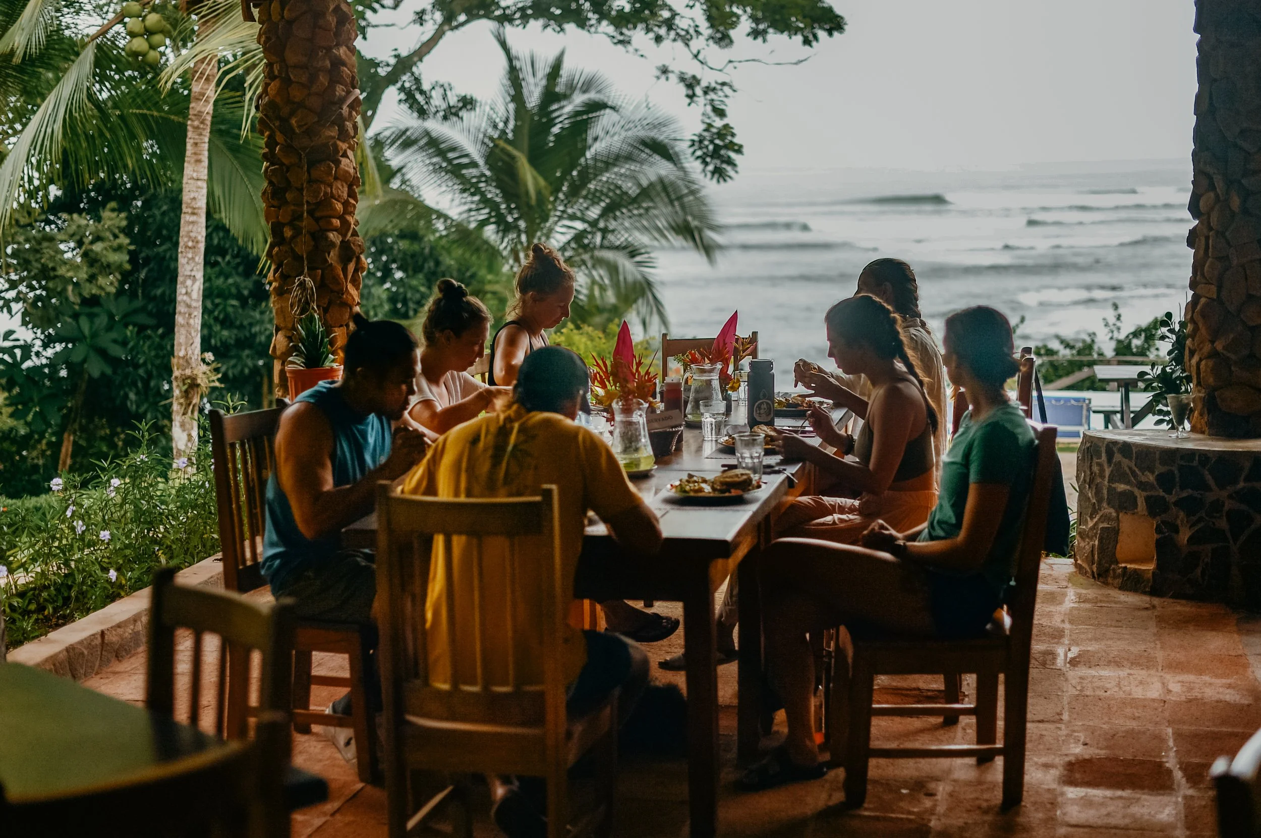 A Day in the Life at a Yoga and Surf Retreat in Panama: What to Expect at Waluaa 7 guests enjoying a meal at our Classic Oceanfront property