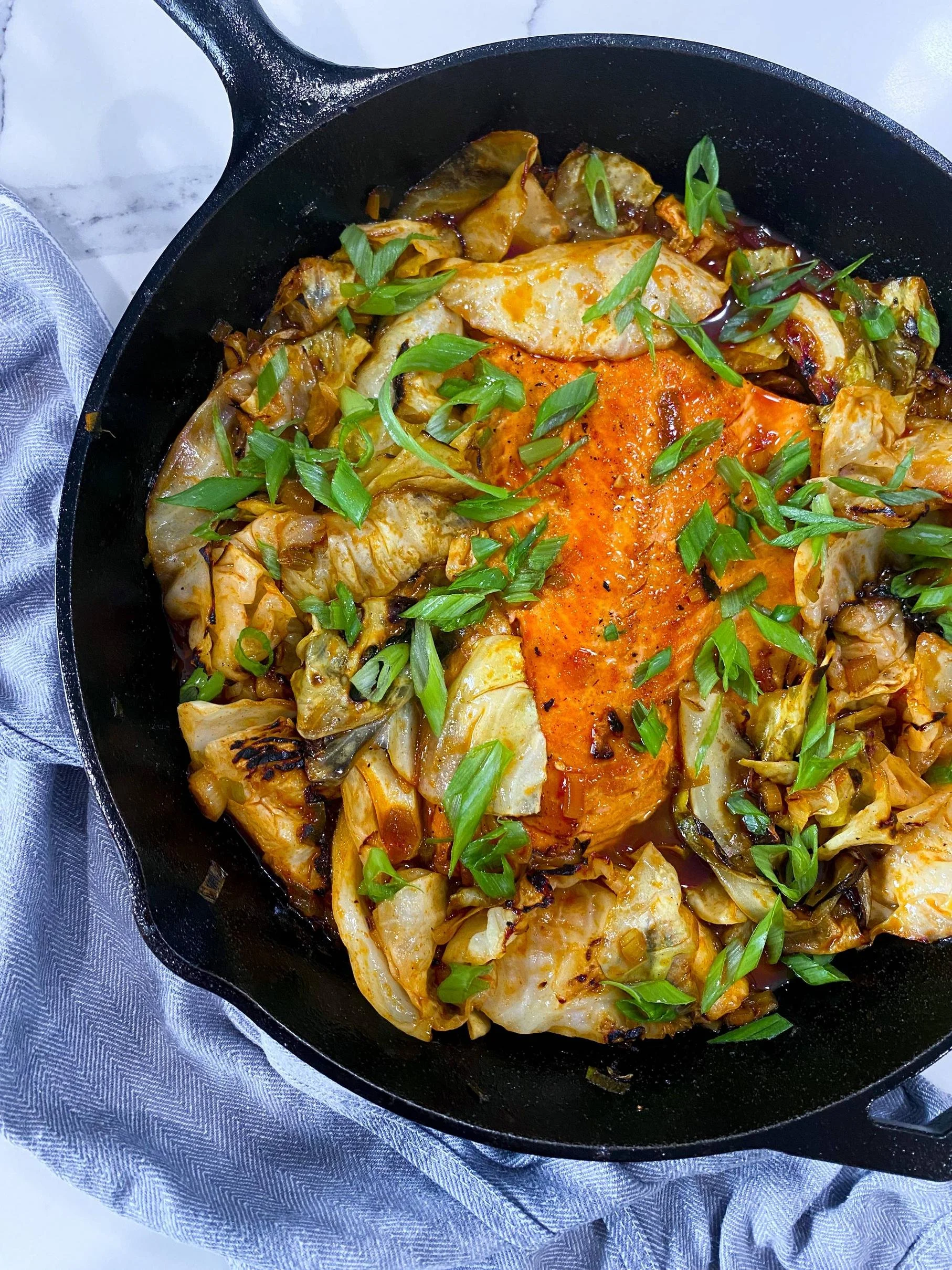 Photo of a dish called Spicy Braised Cabbage with Salmon in a cast iron skillet