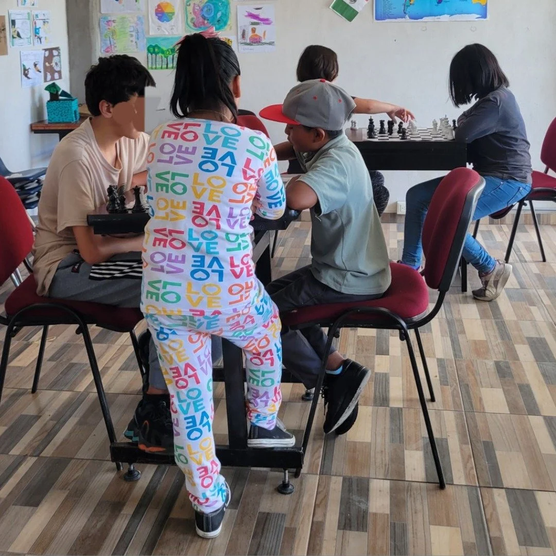 Chess at school. The oldest student is teaching a new student how to play.