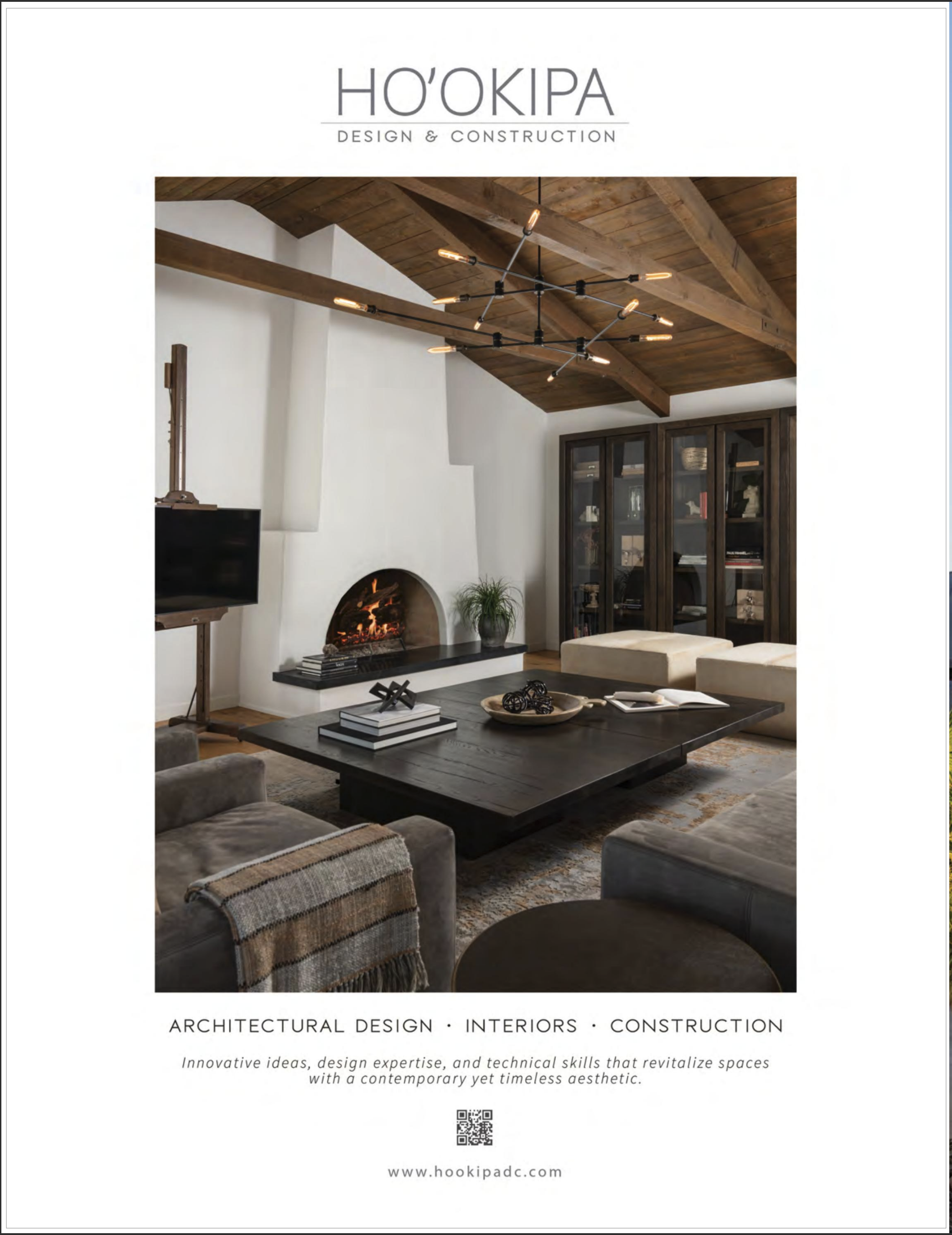 Interior living room with a modern black chandelier, wood beam ceiling, fireplace, dark wooden cabinet, and beige seating around a black coffee table.