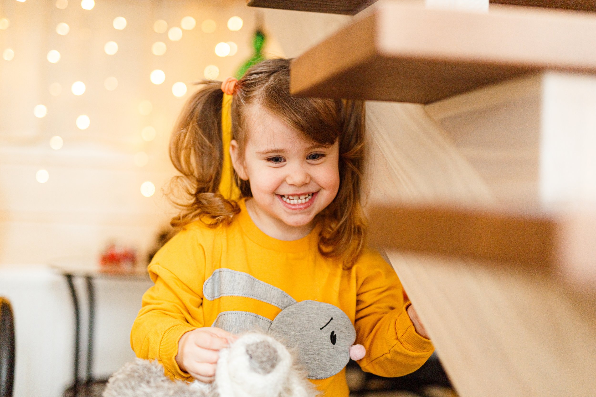 Child playing with toys under stairs