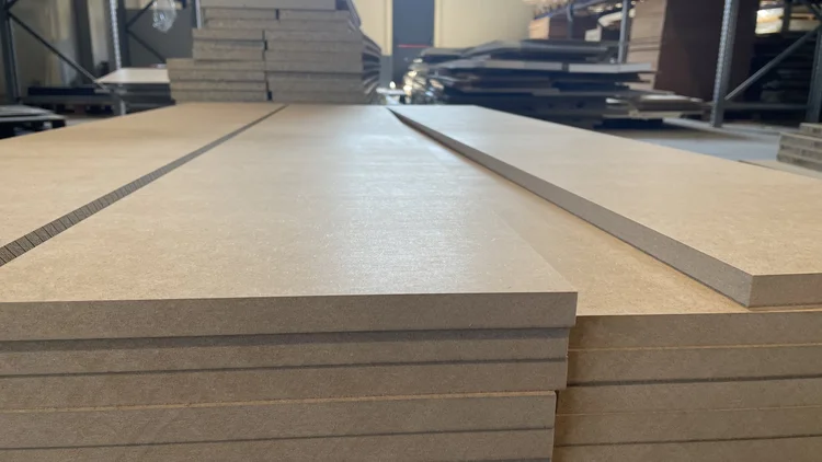 Stacks of smooth MDF sheets on a workshop floor
