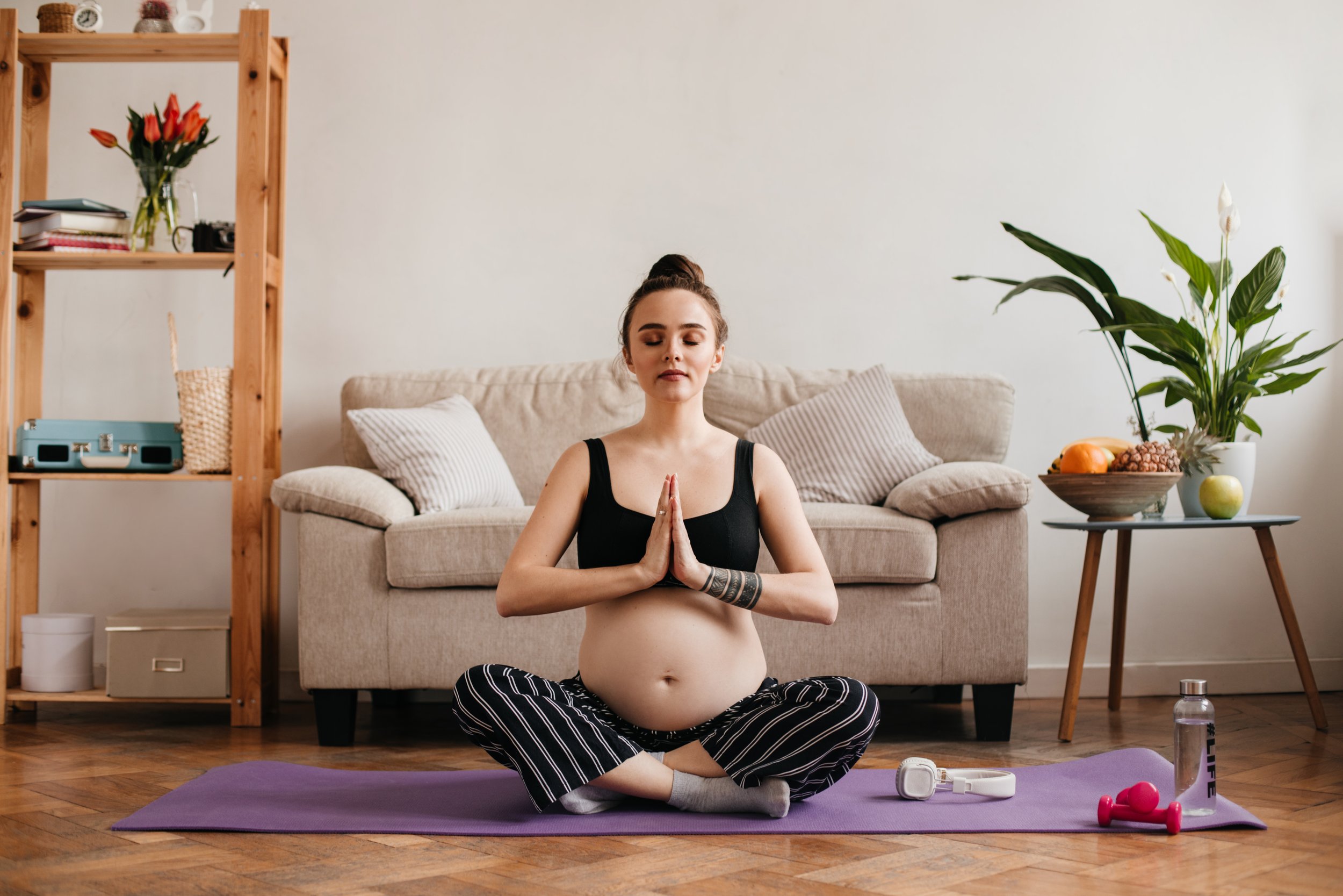 brunette-pregnant-woman-meditating-doing-yoga-living-room (1).jpg