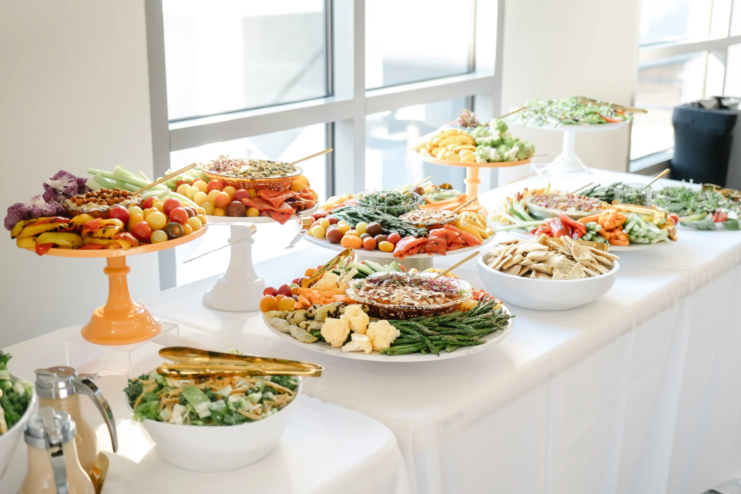 Grazing table with fresh vegetables, dips, crackers, and appetizers by Taylor Made Cuisine