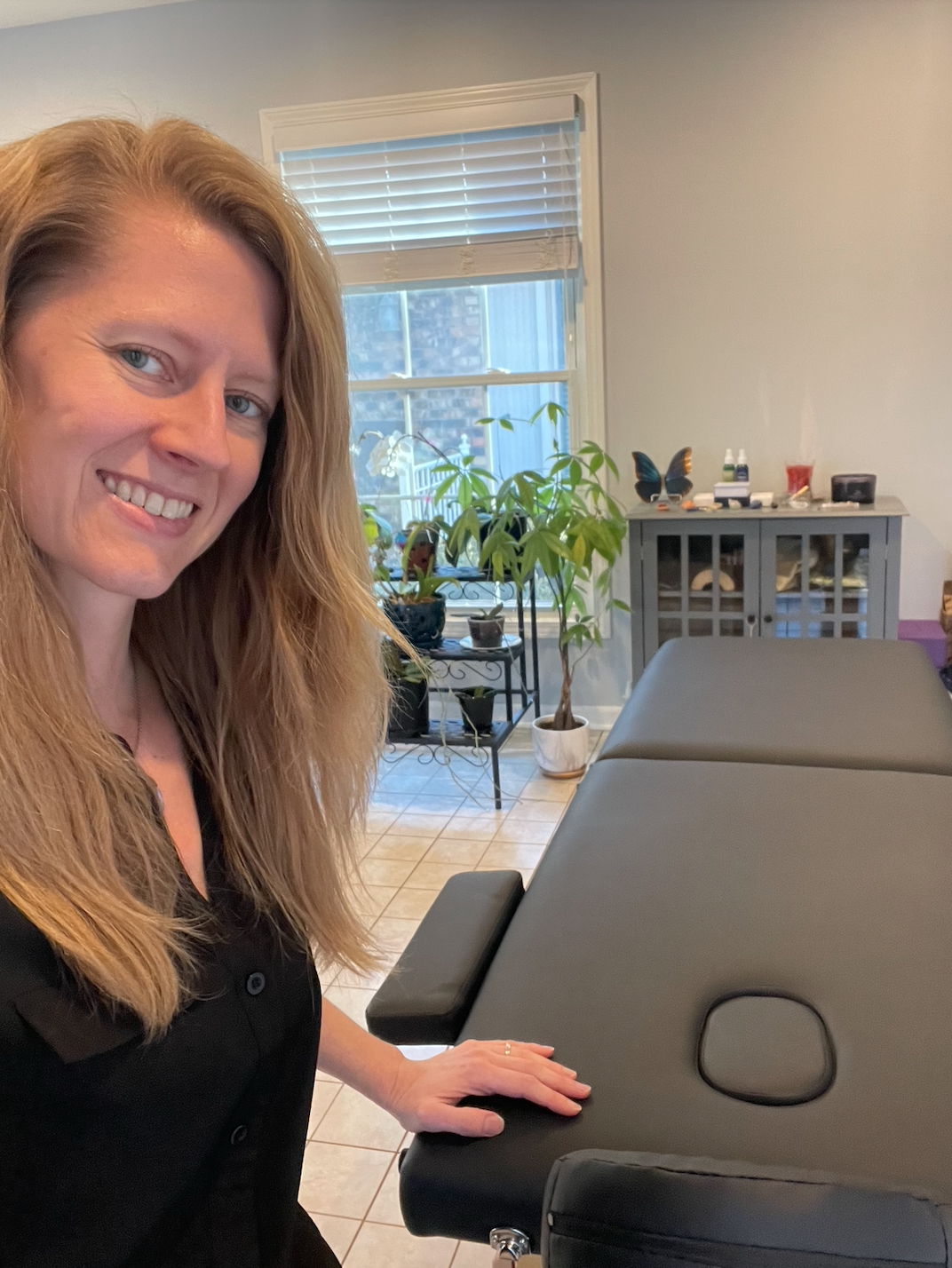 Lindsey Frank in her healing space with her Reiki table