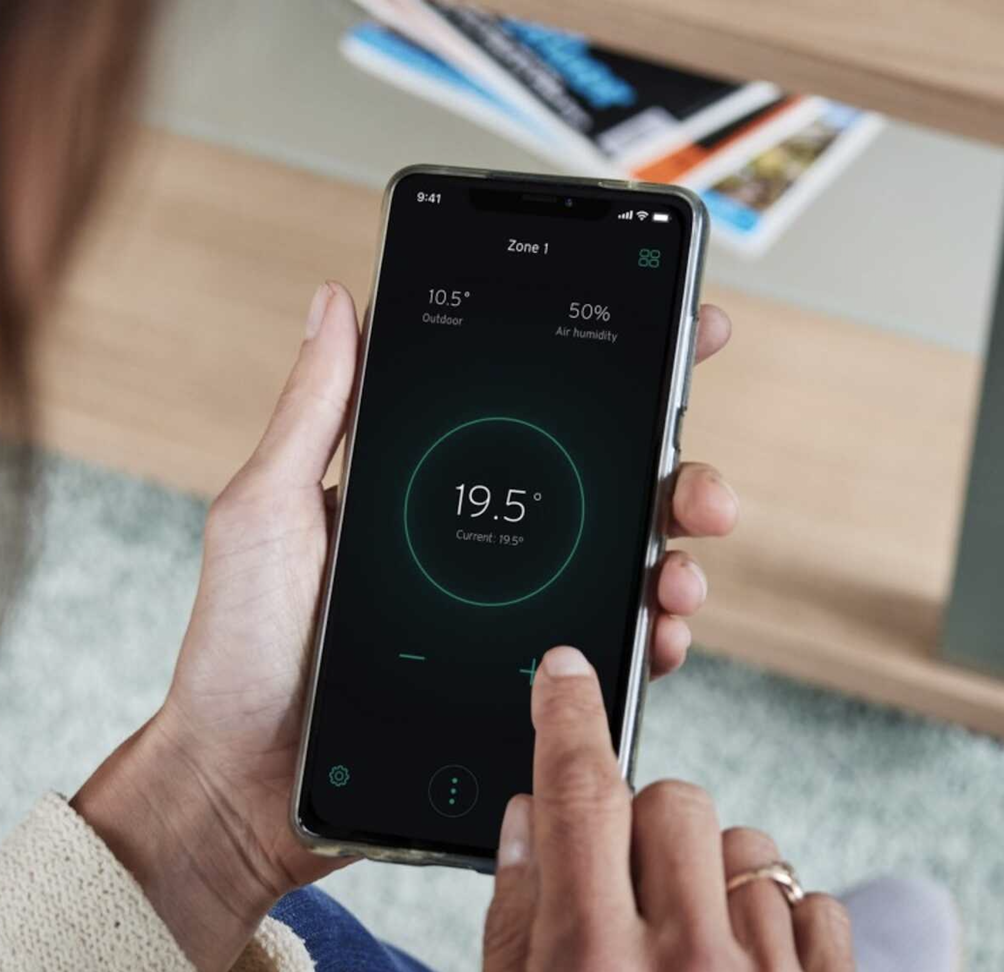 Person adjusting the temperature on a smart thermostat app on a smartphone.