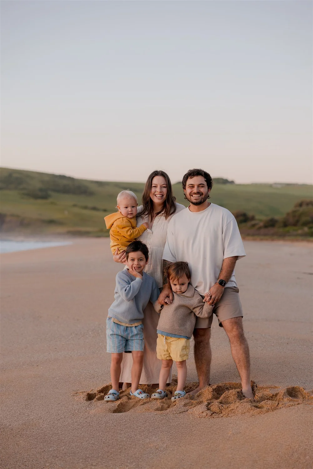 Isaac and Sam Viglione with their three young sons on a beach at sunset