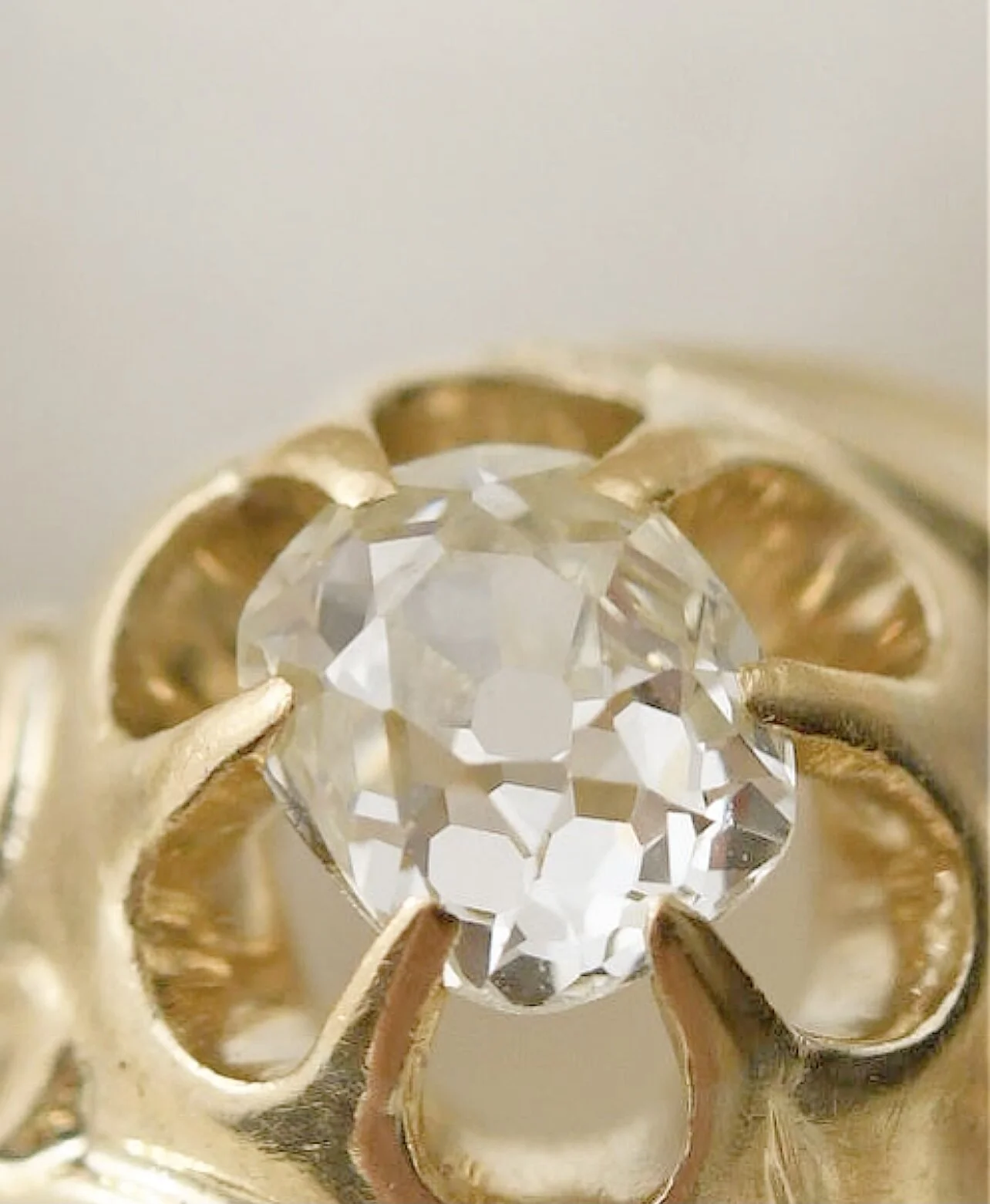 Old mine cut diamond in an antique gold ring seen from above, showing the cushion outline, small table and tall crown