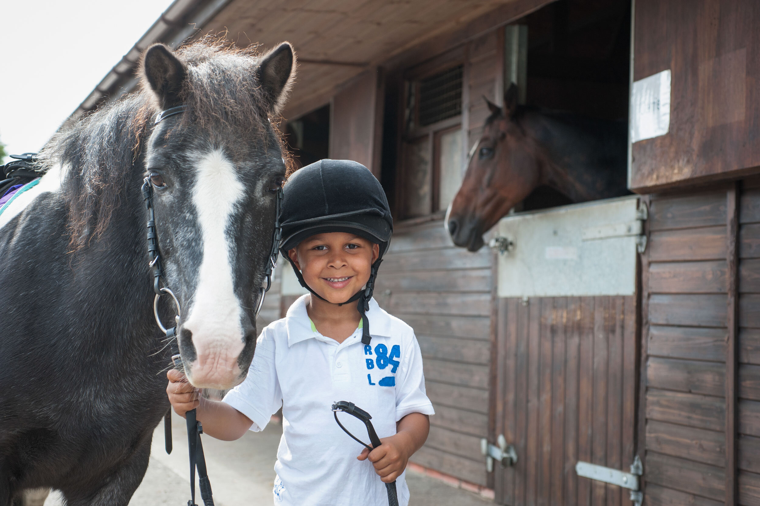  Lee Valley Park. Lee Valley Riding Centre, Lee Bridge Road, London E10. Boy and pony. Shot by Eleanor Bentall, photographer.  