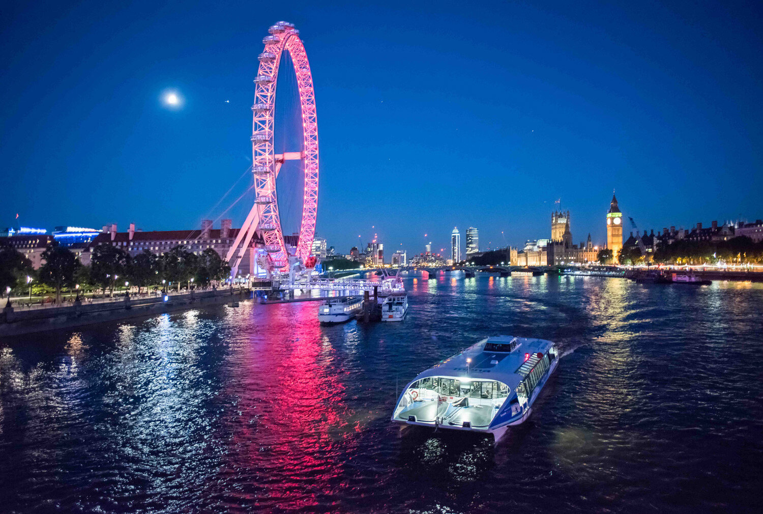  River Services.  Thames Clipper boat London Eye and Houses of Parliament.  Photograph by Eleanor Bentall.   