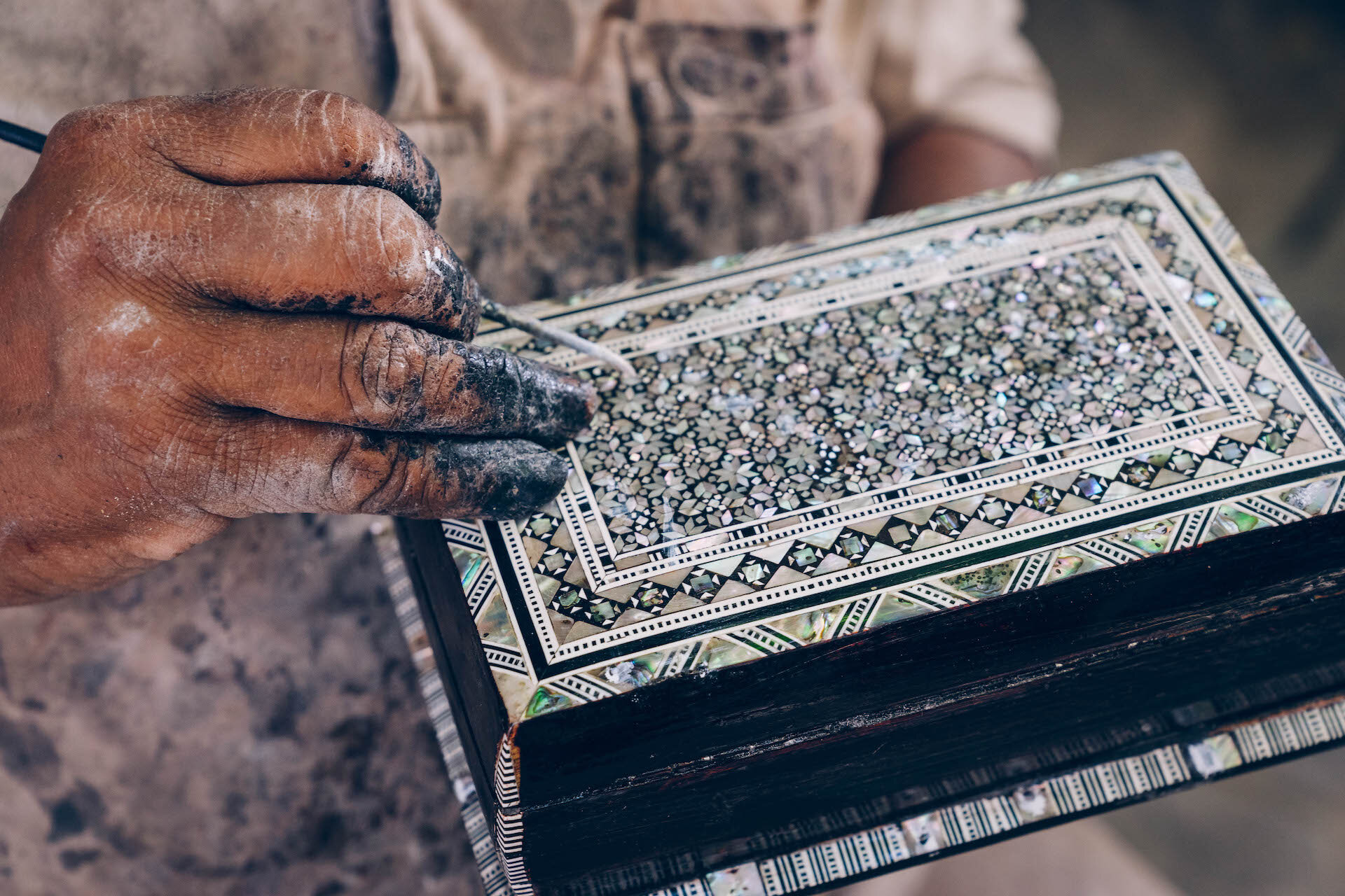 An artisan applying the finishing touches to a box inplaid with mother-of-pearl