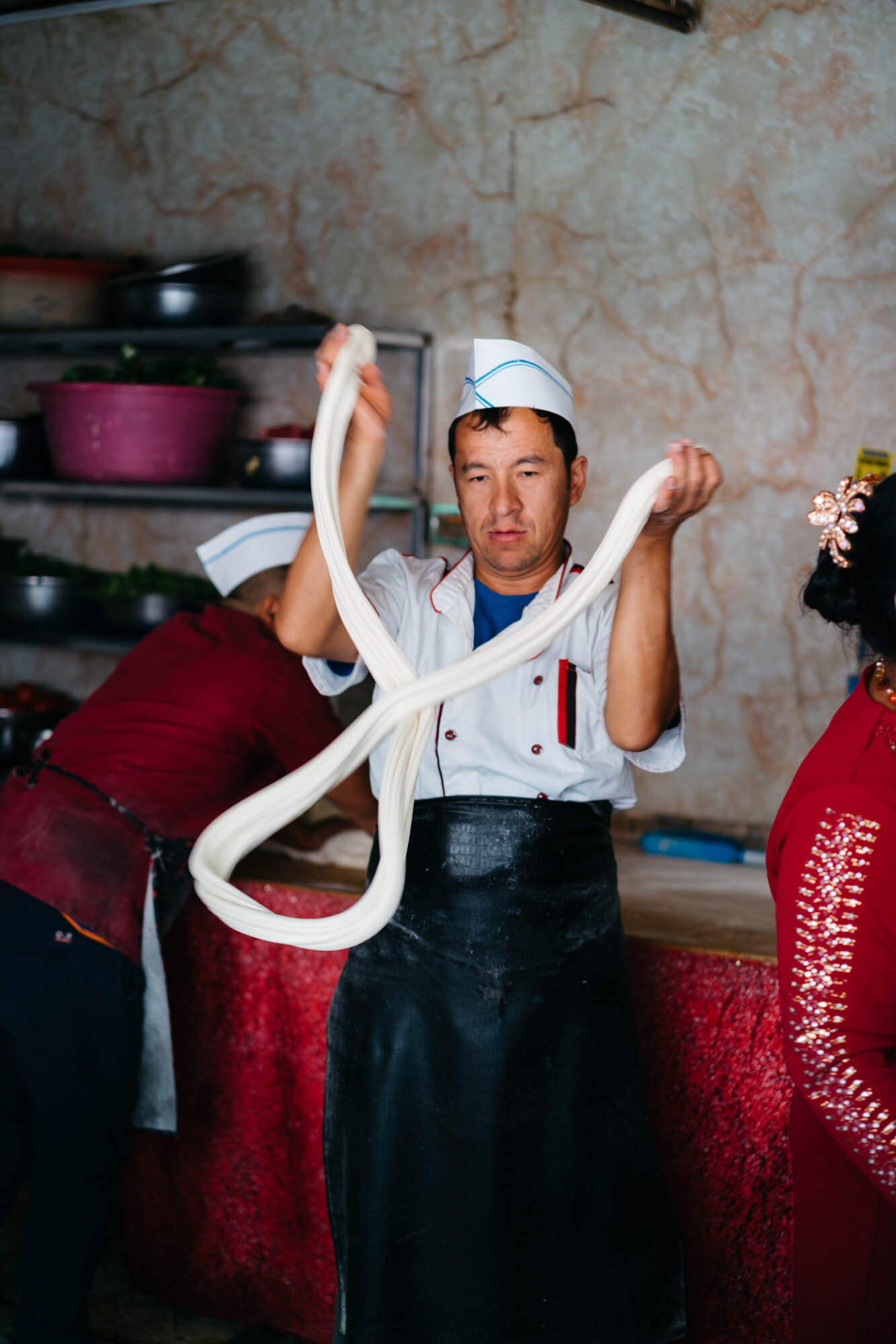  A cook making hand pulled noodles at the bazaar 