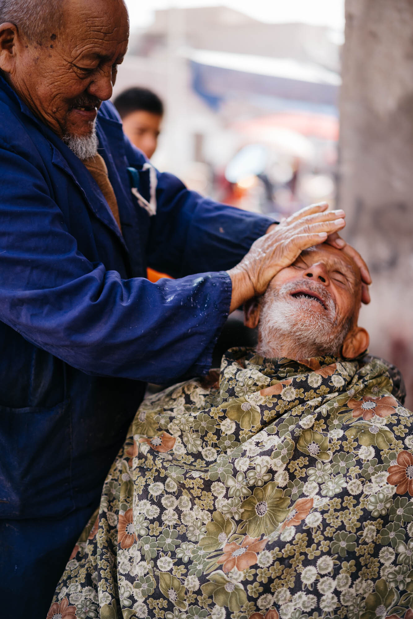  A barber giving face massage at the bazaar 