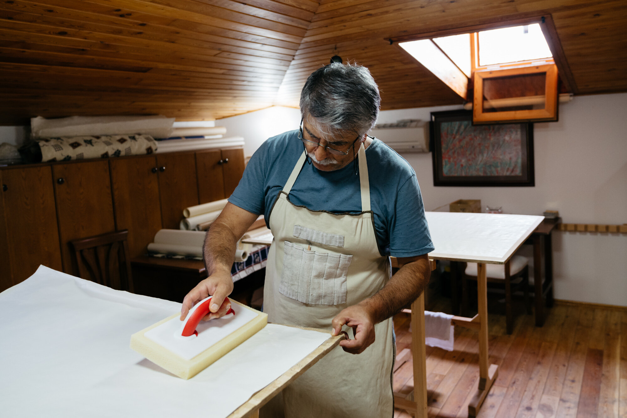  One of Ayten's family members preparing paper for calligraphy and illumiation. He is covering the paper with a thin layer of egg white. 