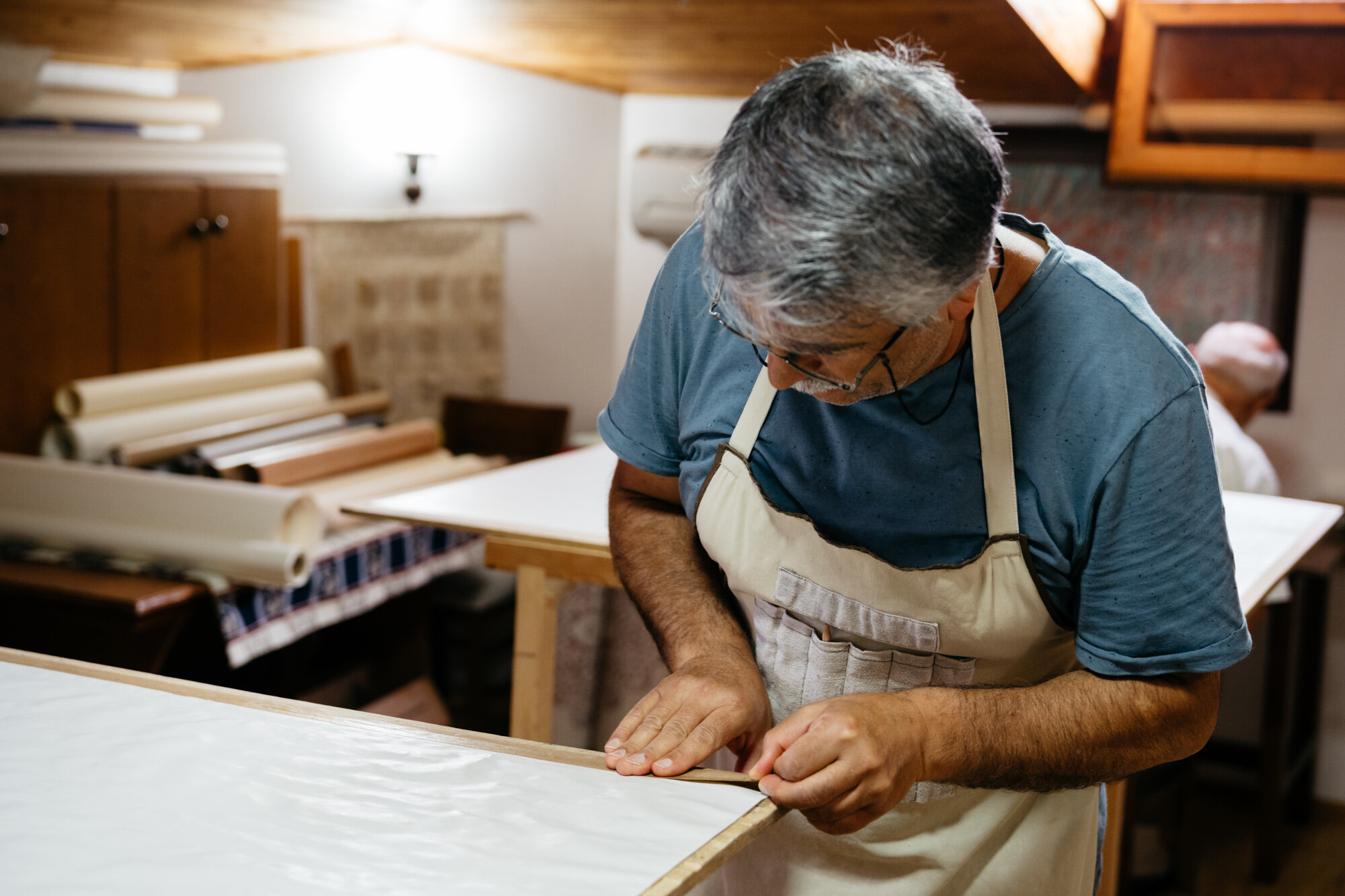  One of Ayten's family members preparing paper for calligraphy and illumiation. He is covering the paper with a thin layer of egg white. 