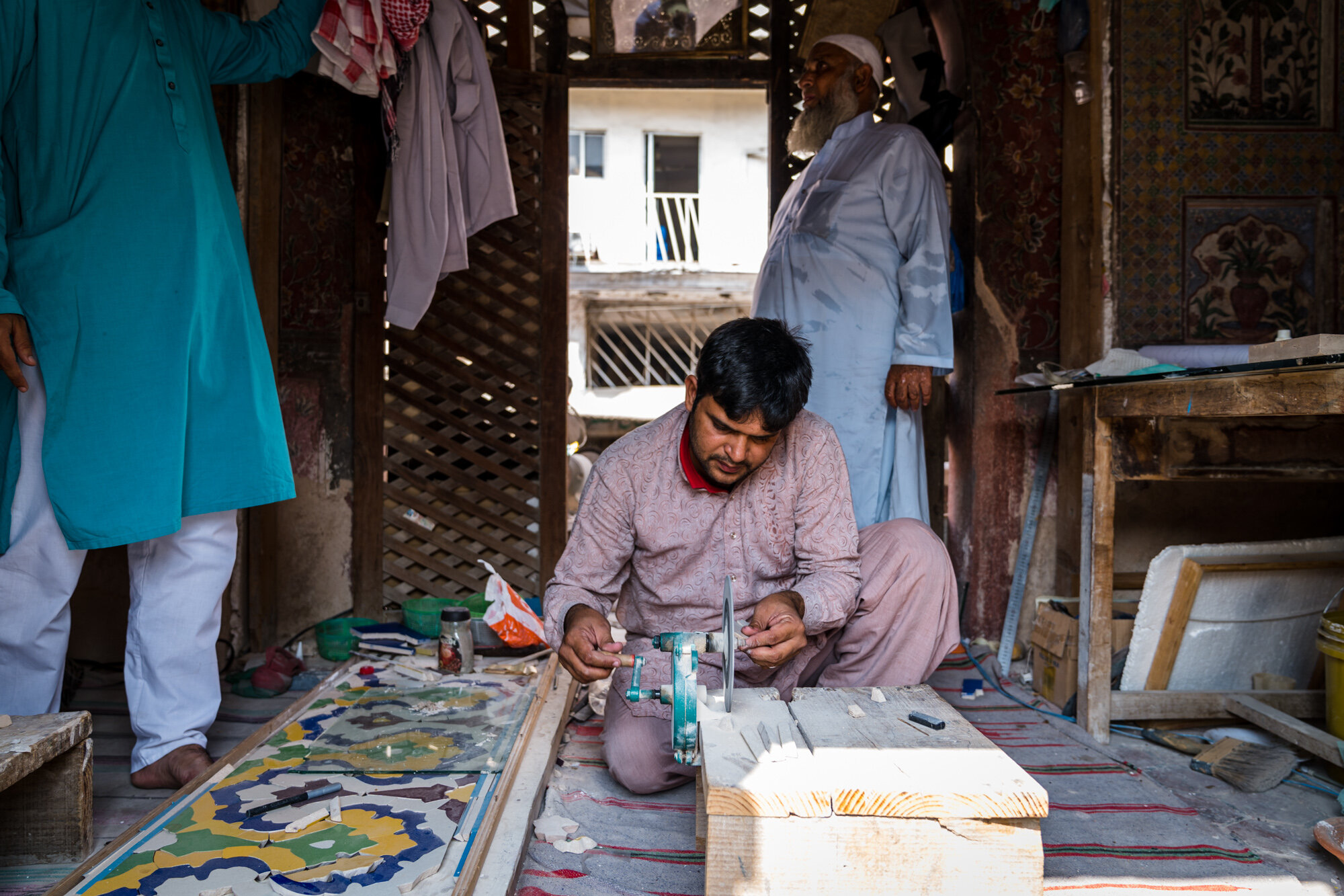  A tile maker creating individual pieces of the mosaic tile work 