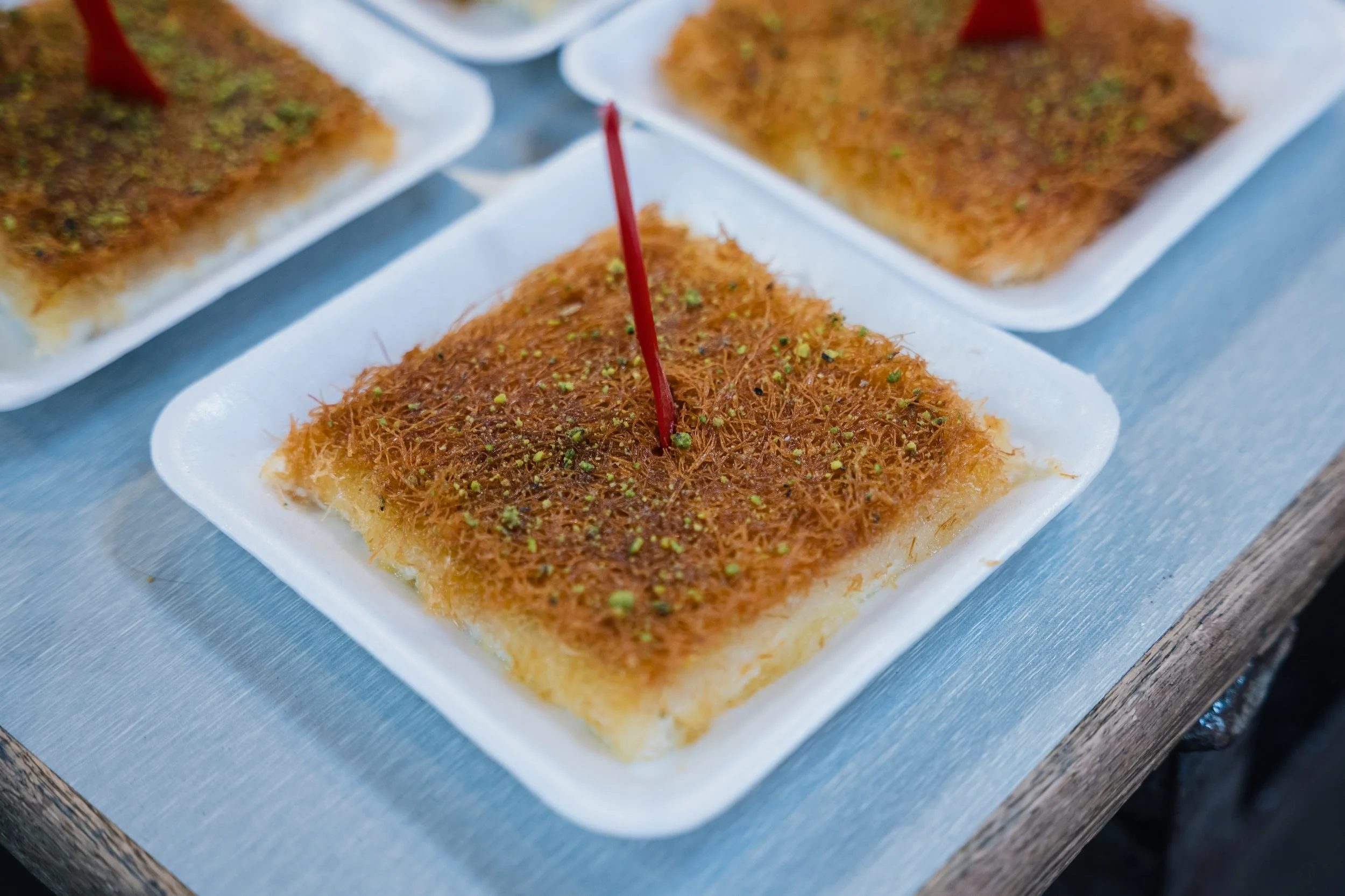  Knafeh, a traditional Middle Eastern dessert known for its contrast of a crispy, golden pastry crust, a gooey cheese or cream filling, and a sweet, fragrant syrup 