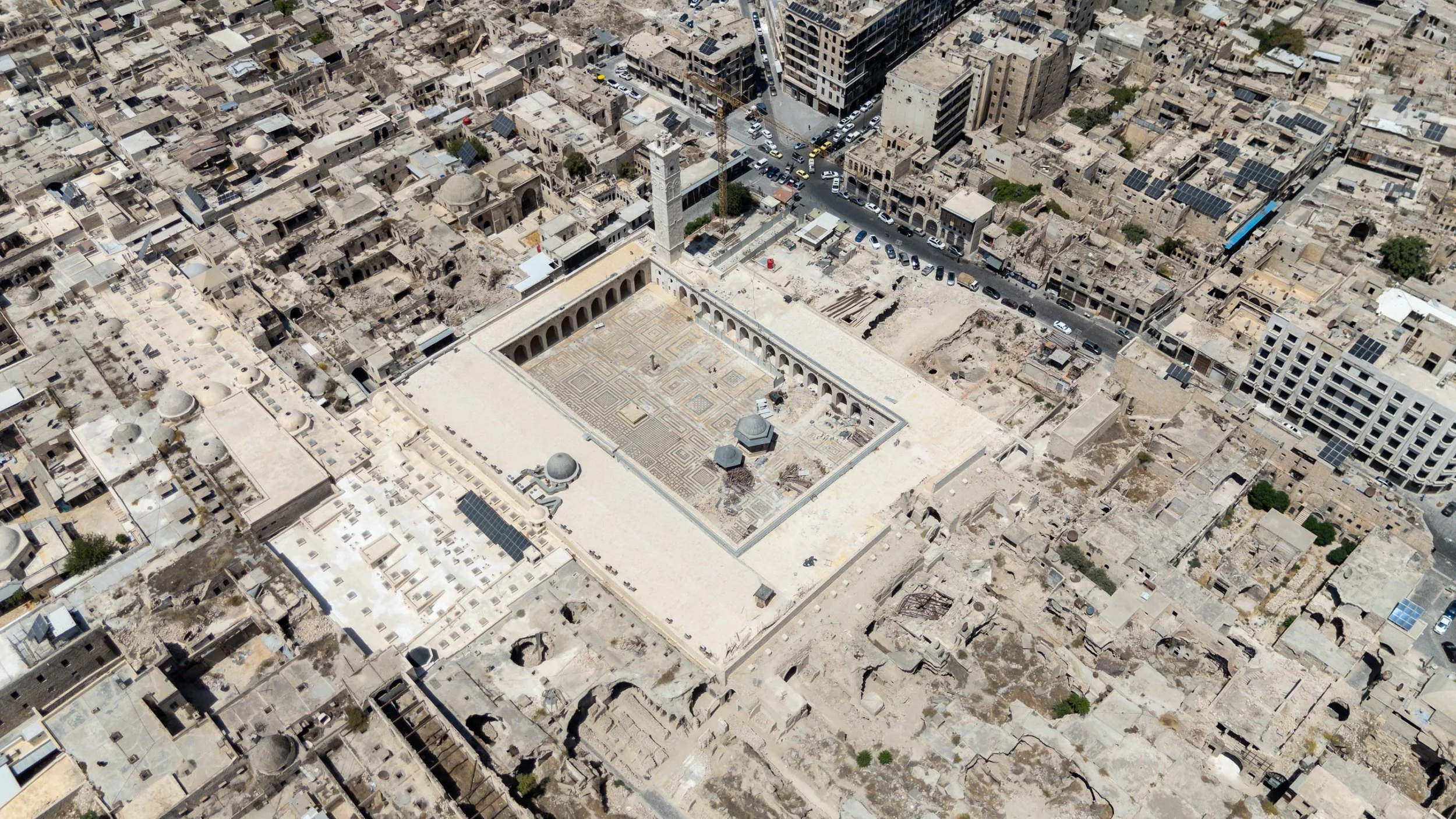  An aerial view of the Great Mosque of Aleppo. Destruction of the souk can be seen on the right hand side and sections that have been restored by the Aga Khan Trust for Culture can be seen on the left hand side; the whiter parts. 