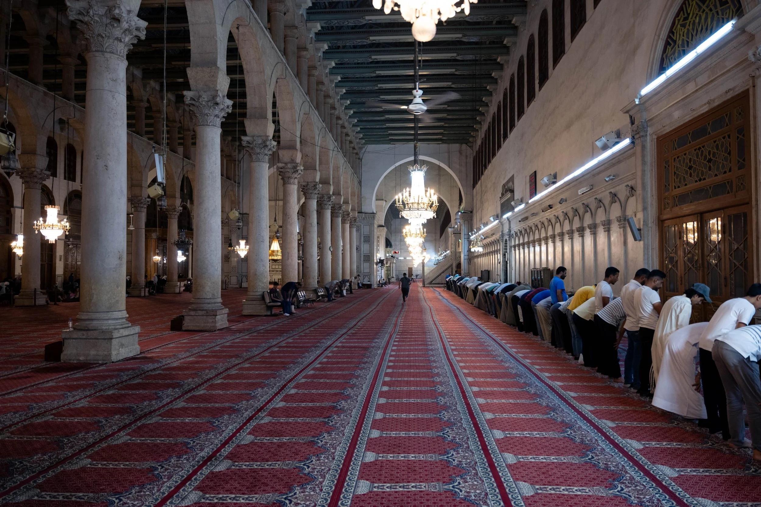  A man runs to find a space facing the wall to pray. 