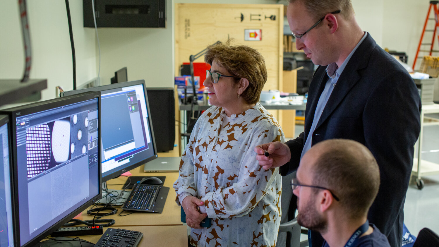  Elizabeth Walder (left) and Scott Bailey (center) examine cryo-EM grid images. 