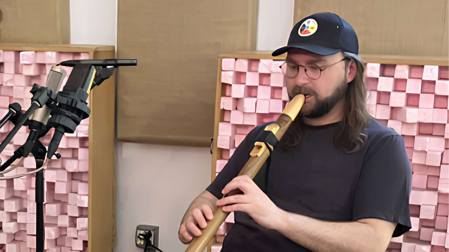 Jack Langdon, musician and Outer Ear Sessions pilot program participant, plays the bibigwan (an Ojibwe wooden flute) at Experimental Sound Studio in May 2026.
