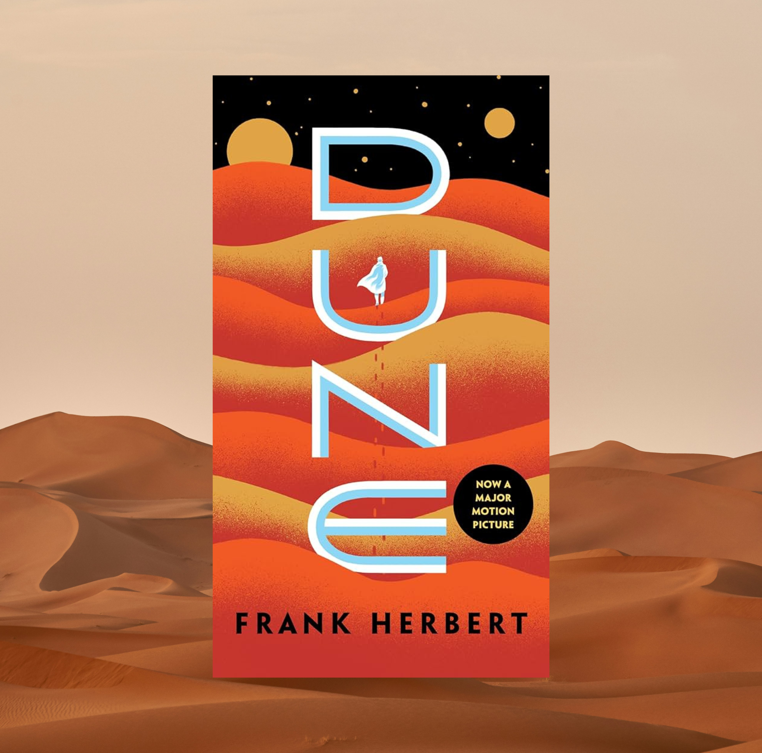 The cover of Dune by Frank Herbert on a background of a photo of a dessert sand dune.